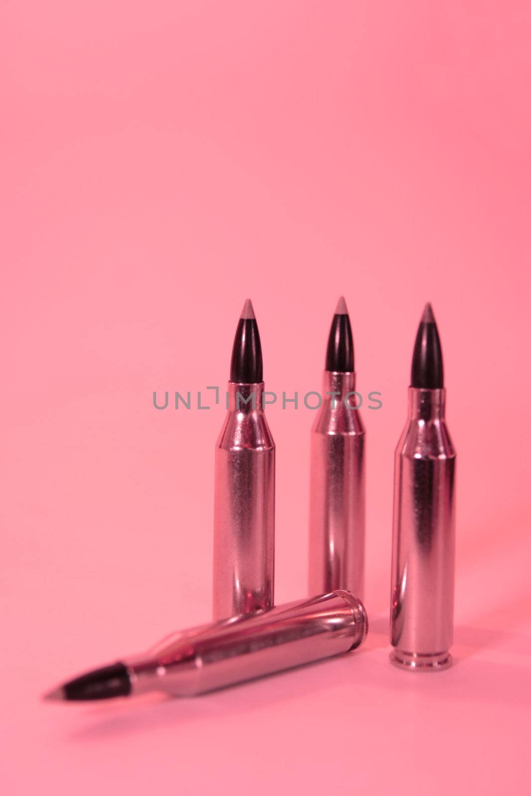 ammunition all in a row on a pink background