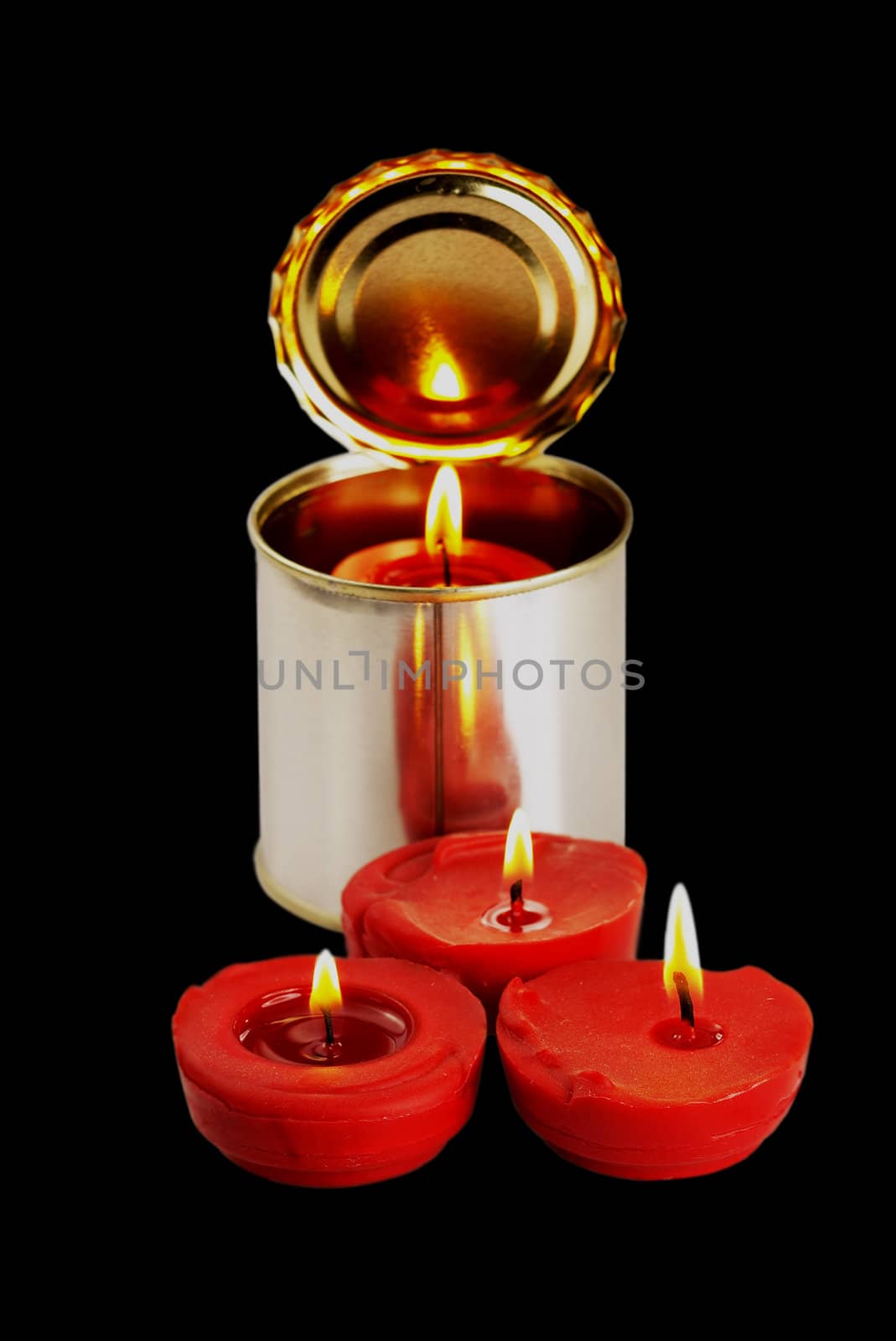 red candle on a tin can over black background