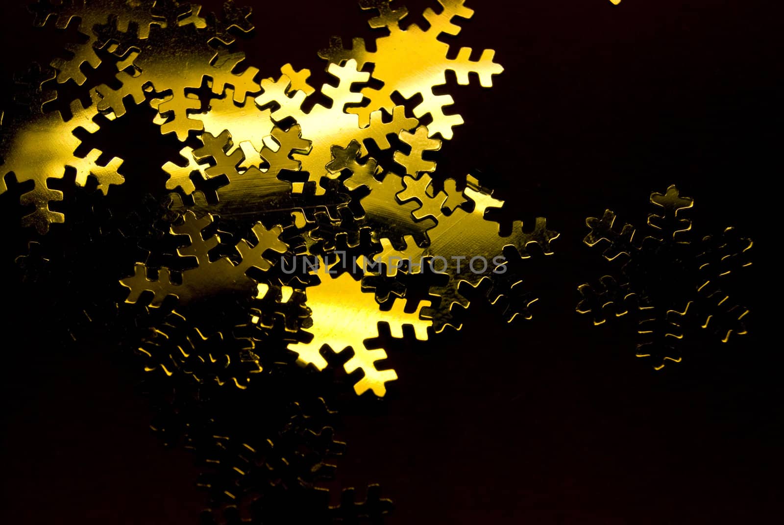 lots of golden snowflakes on a black background
