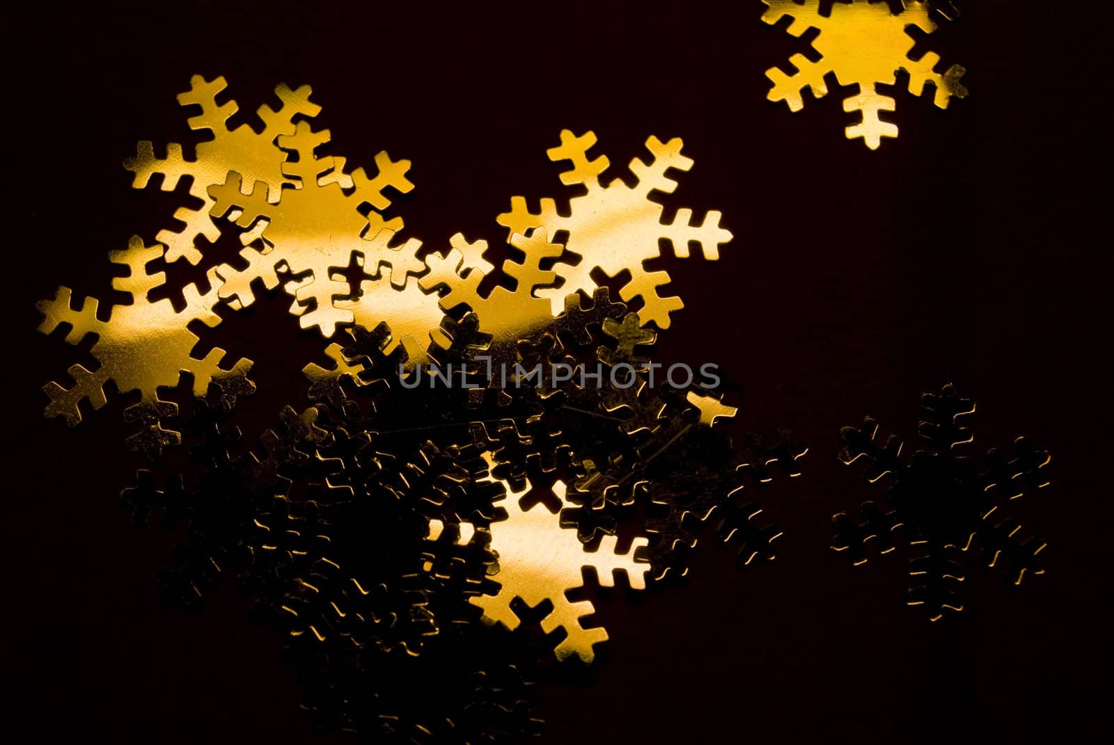 lots of golden snowflakes on a black background