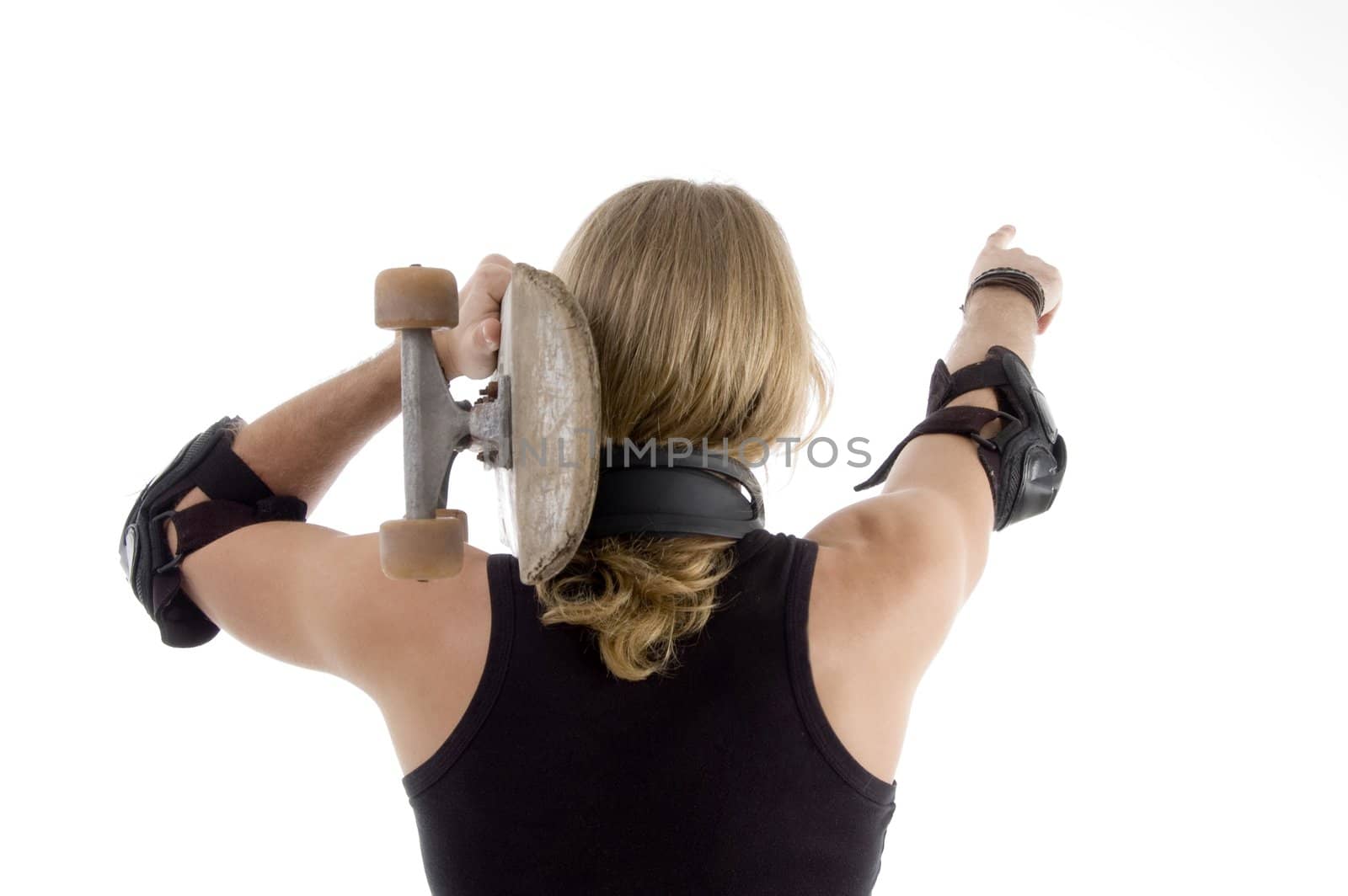 caucasian skateboarder pointing backwards with white background