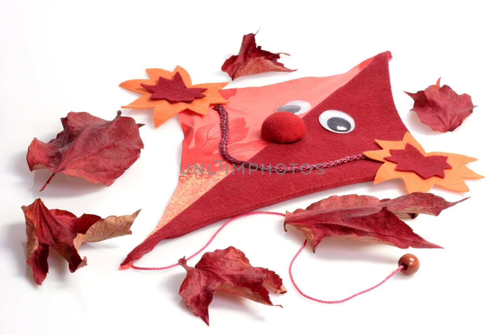 Red deco kite of felt with leaves on white background
