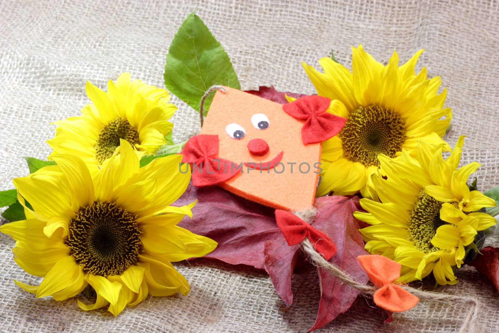 Sunflowers with autumn foliage and felt kite in a basket
