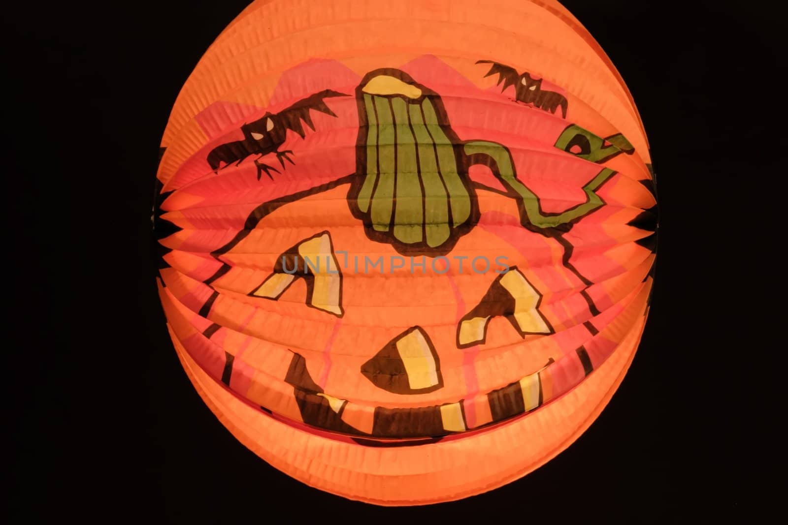 Paper lantern with pumpkin-face - isolated on black background