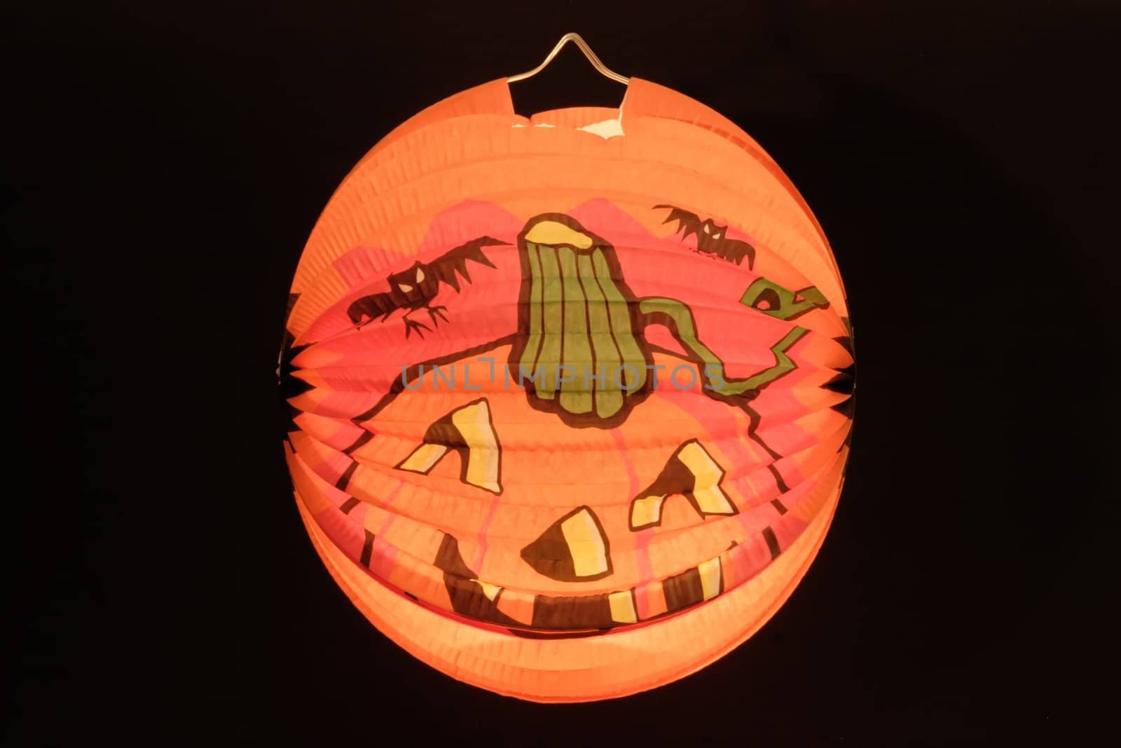 Paper lantern with pumpkin-face - isolated on black background