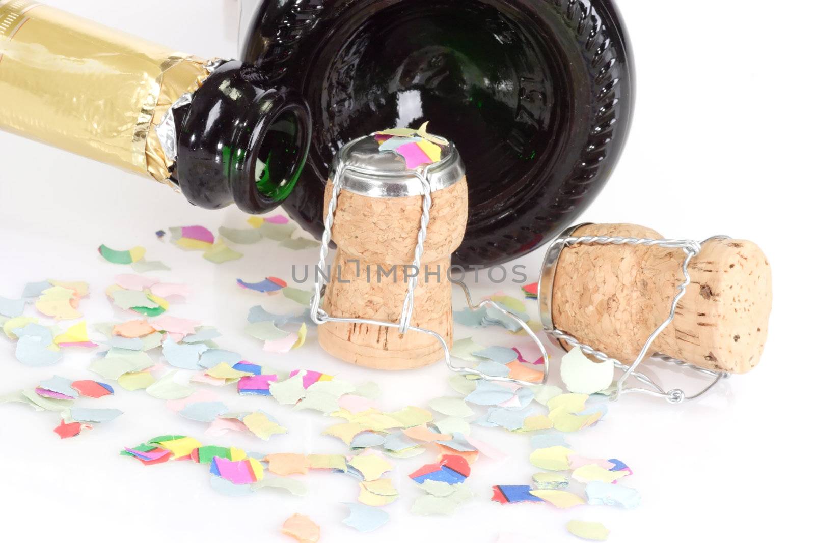 Empty champagne bottles, corks and confetti on white background