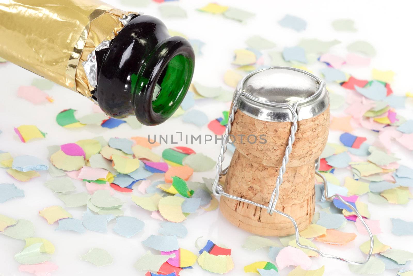 Empty champagne bottle, cork and confetti on white background