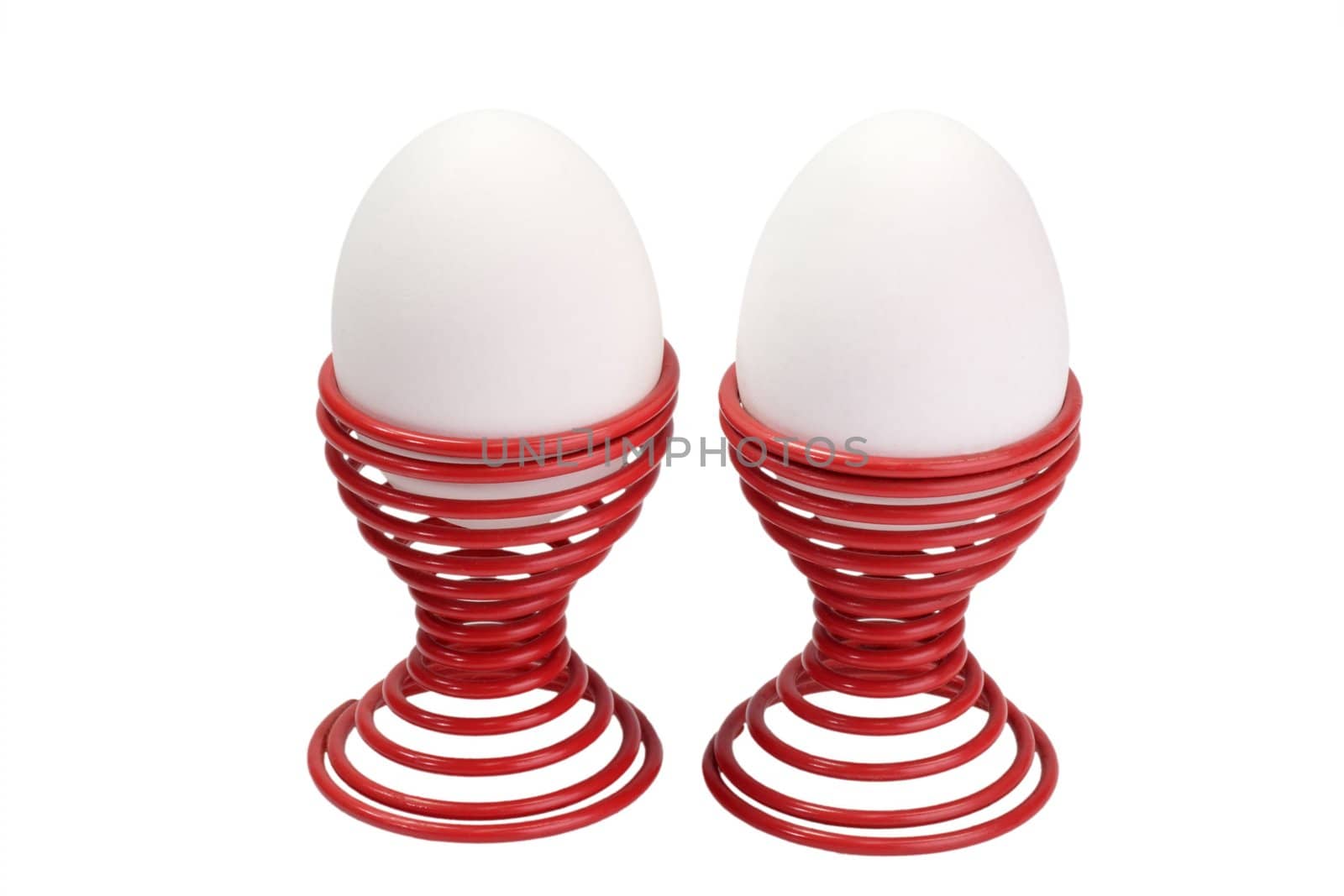 Two white eggs in eggcups - isolated on white background