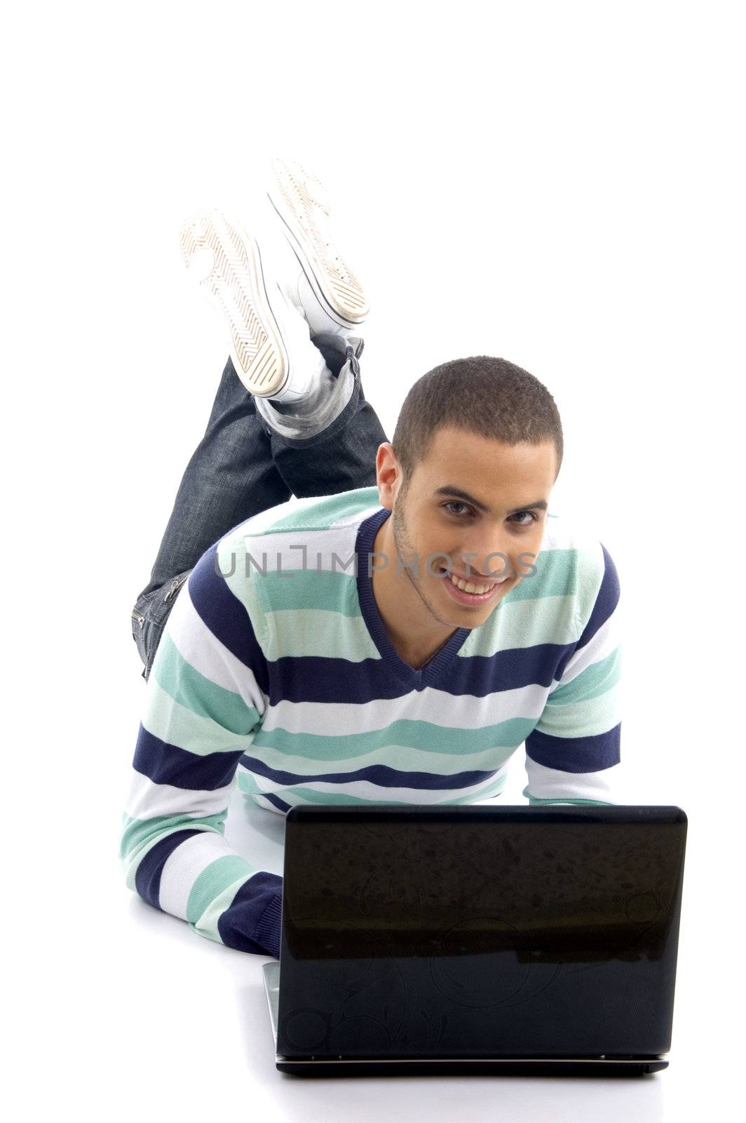 young male lying on the floor and busy with laptop on an isolated white background