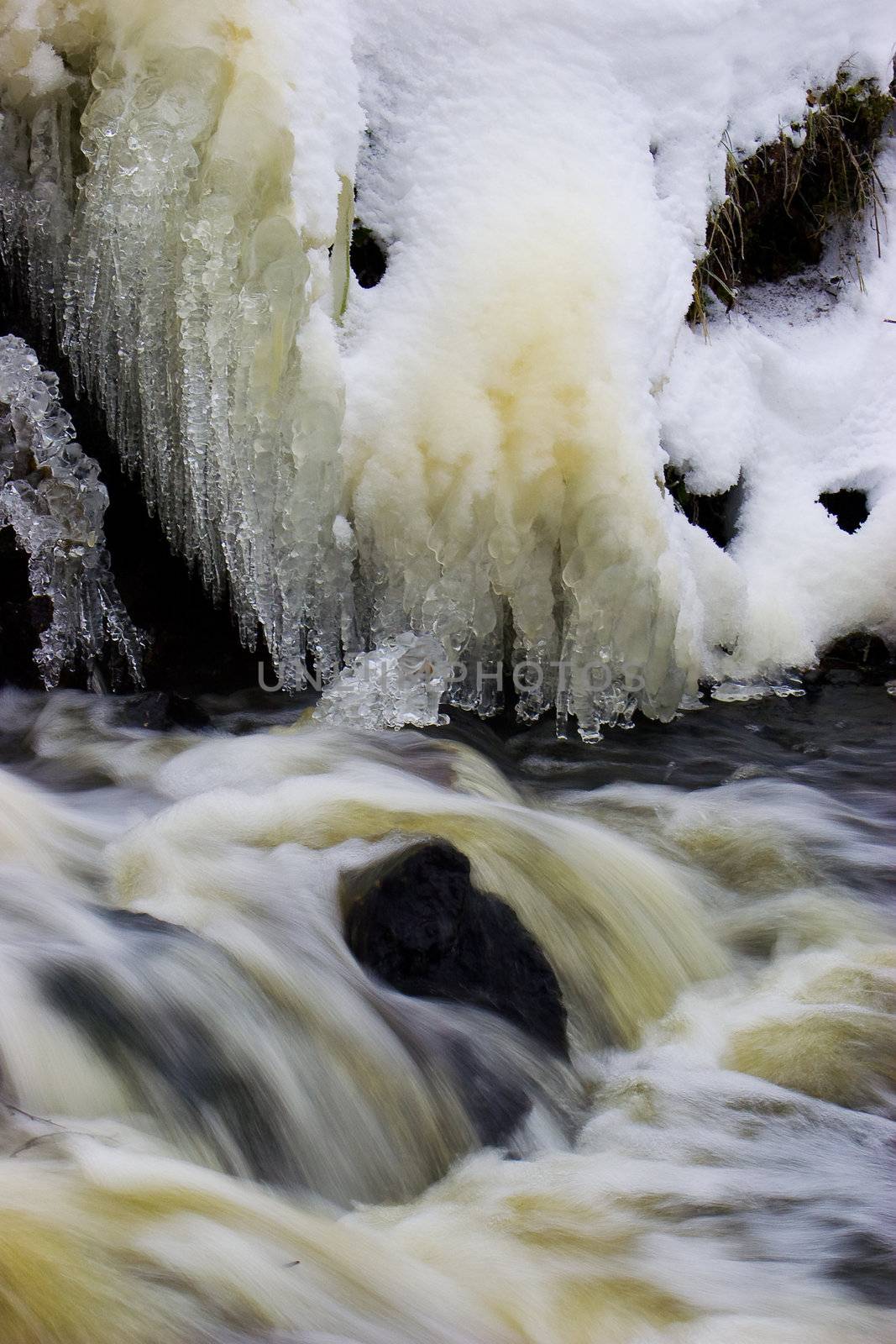Frozen Waterfall with icicles in cold winter day