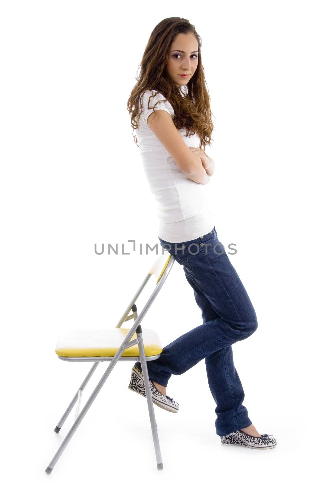 attractive young female standing with support of chair against white background