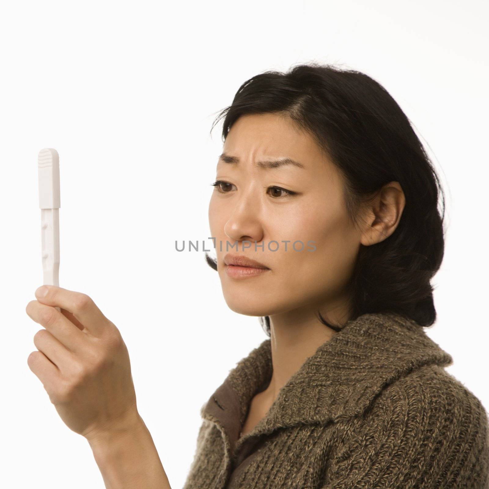 Woman holding pregnancy test. by iofoto