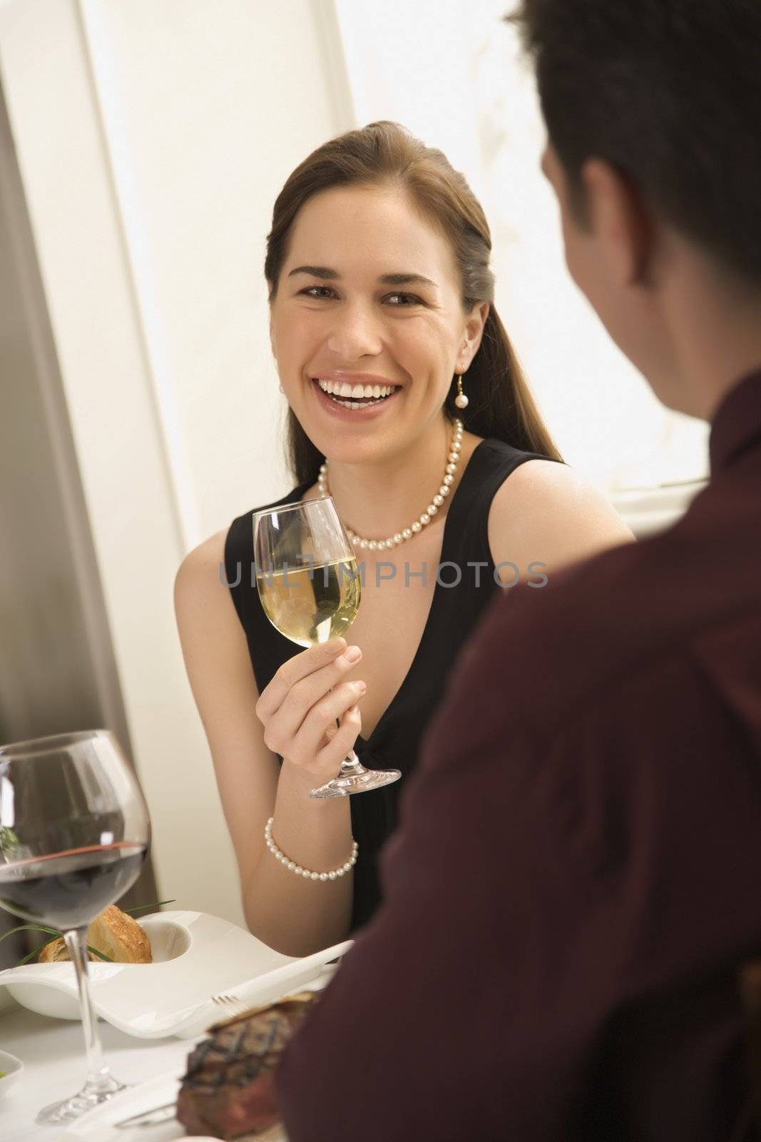 Mid adult Caucasian couple smiling and drinking wine and dining.