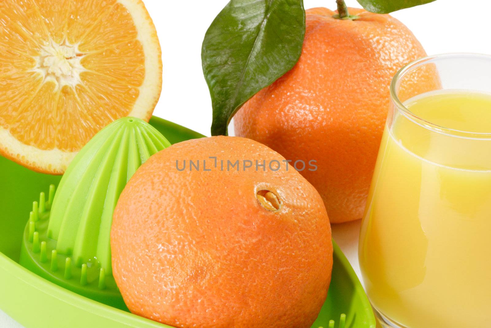 Fresh Oranges and Orange Juice with green juicer