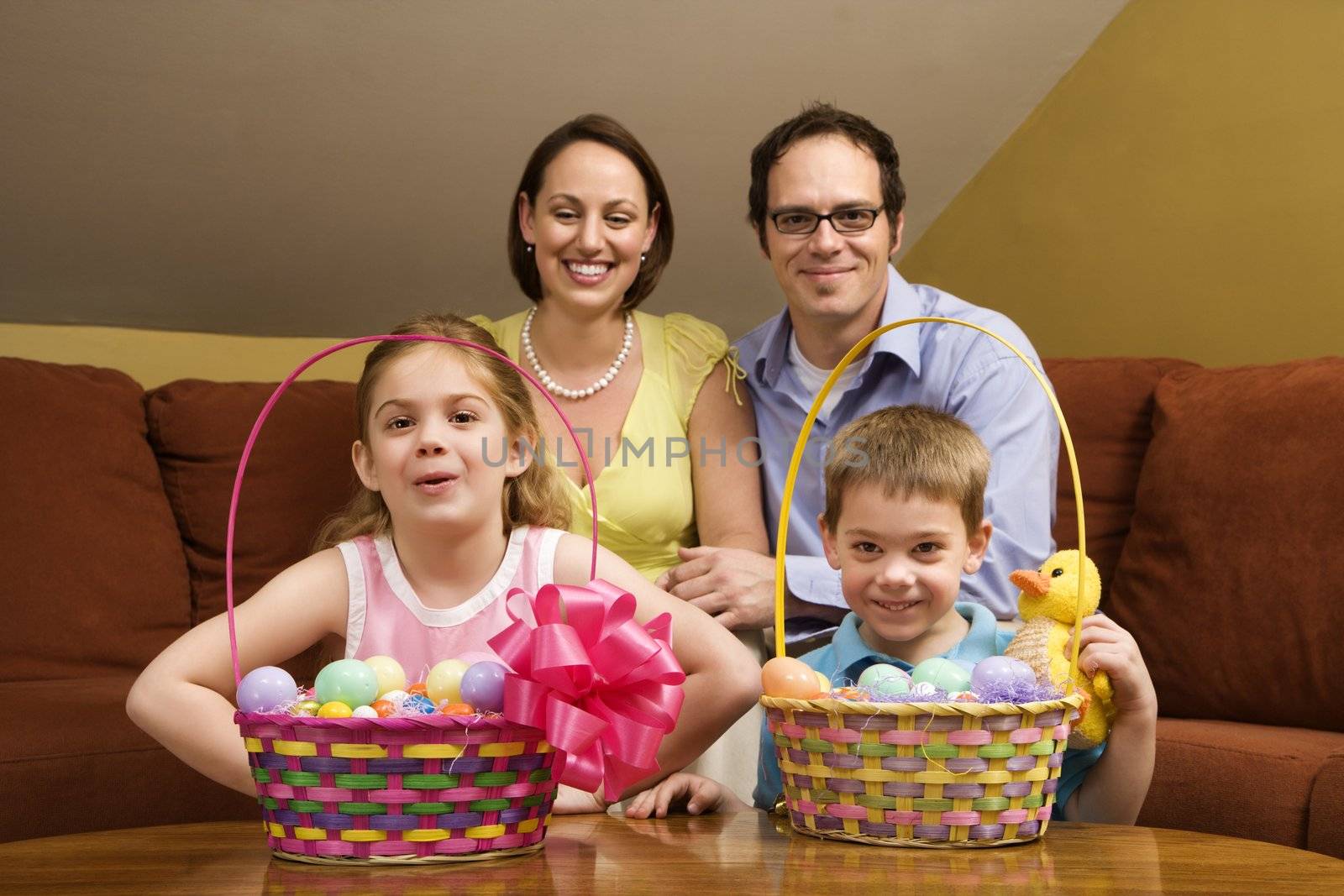Caucasian family with Easter baskets looking at viewer.