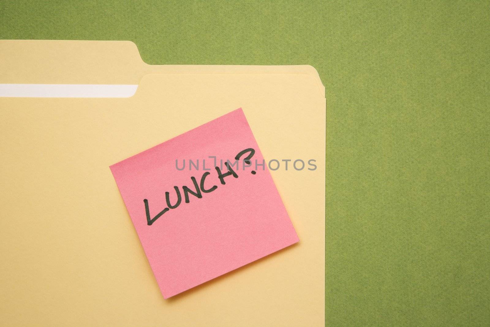 Folder with pink sticky note reading lunch on a green background.