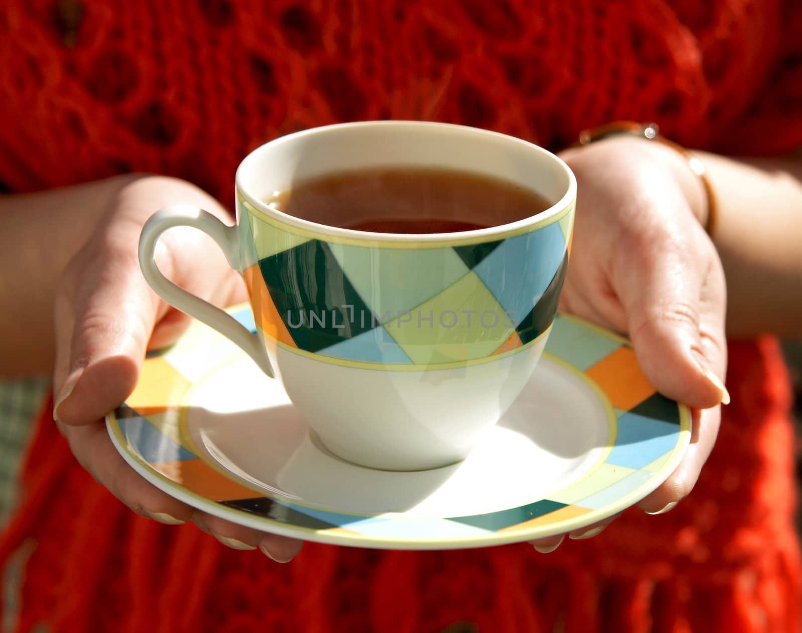 cup of tea in hands of woman by amaxim