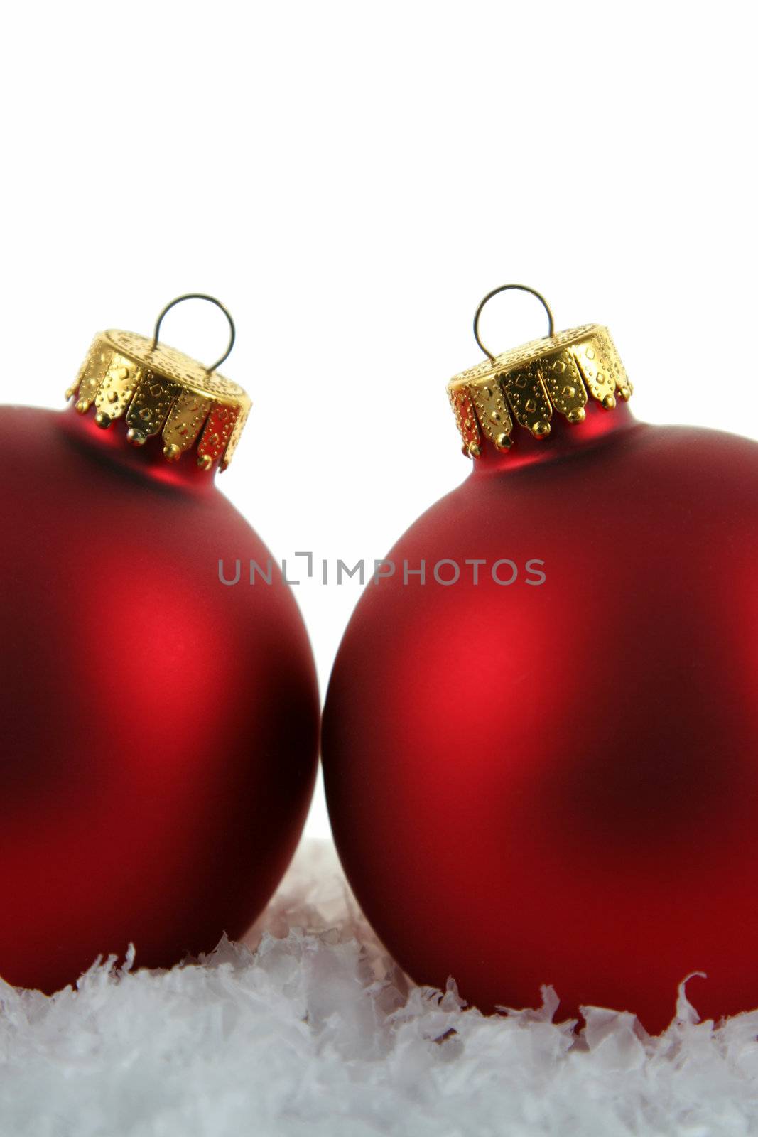Two red Christmas bauble backed by a white background.
