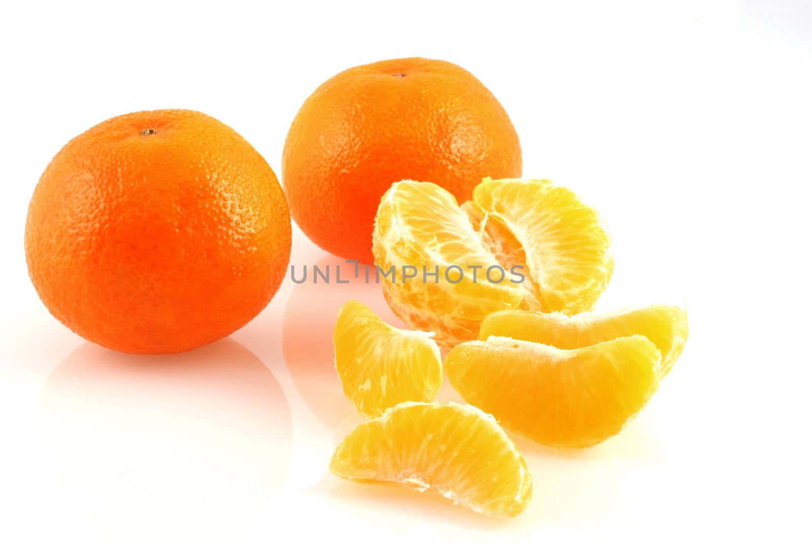 Three mandarins on white; one peeled..two in skin.