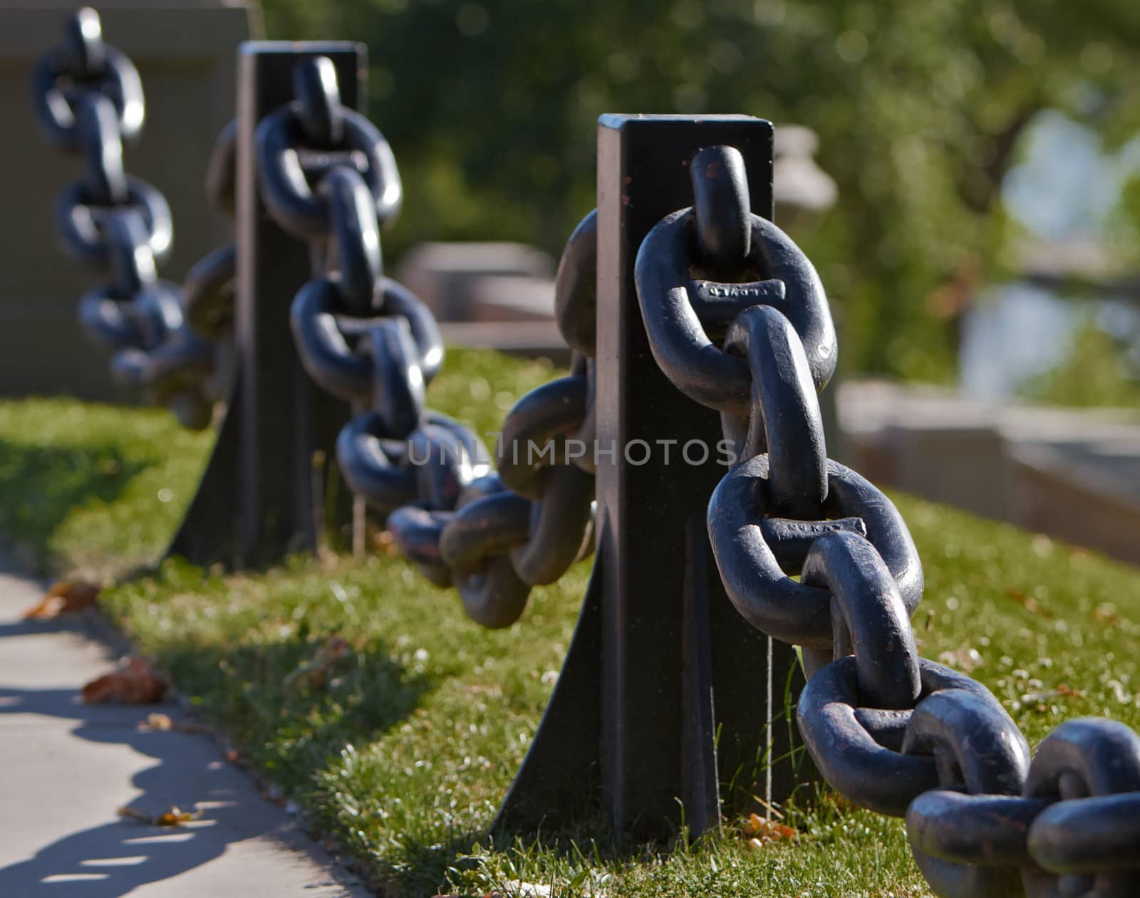 Black Steel Anchor Chain used for a railing againt grass lawn