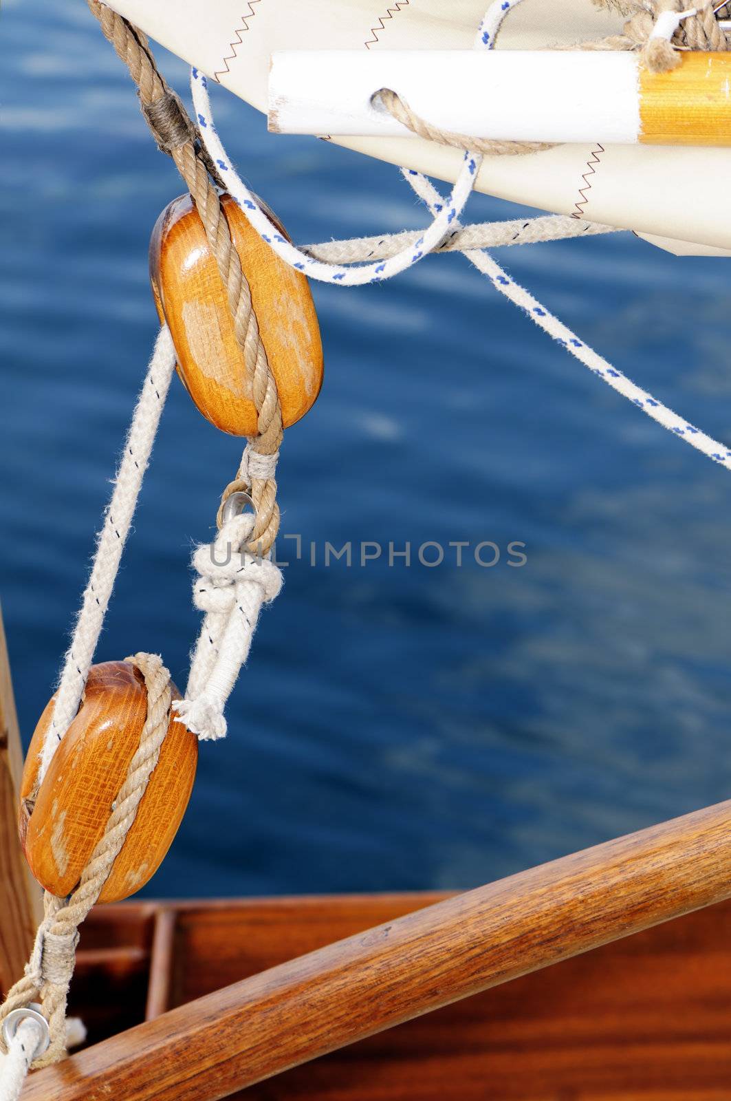 Close-up of wooden blocks on a old-fashioned sailboat with blue sea in background