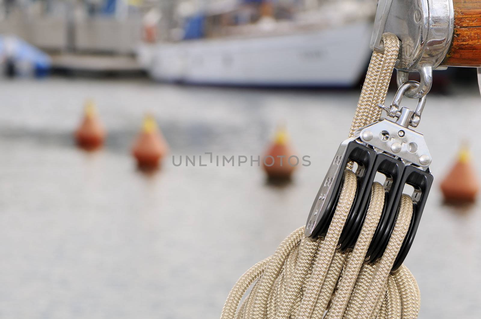 Pulley with rope on a sailboat with buoys in background