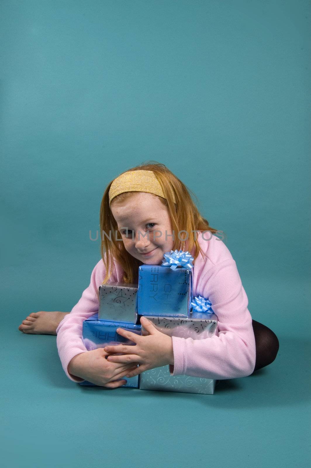 little red head girl is holding all her christmas presents