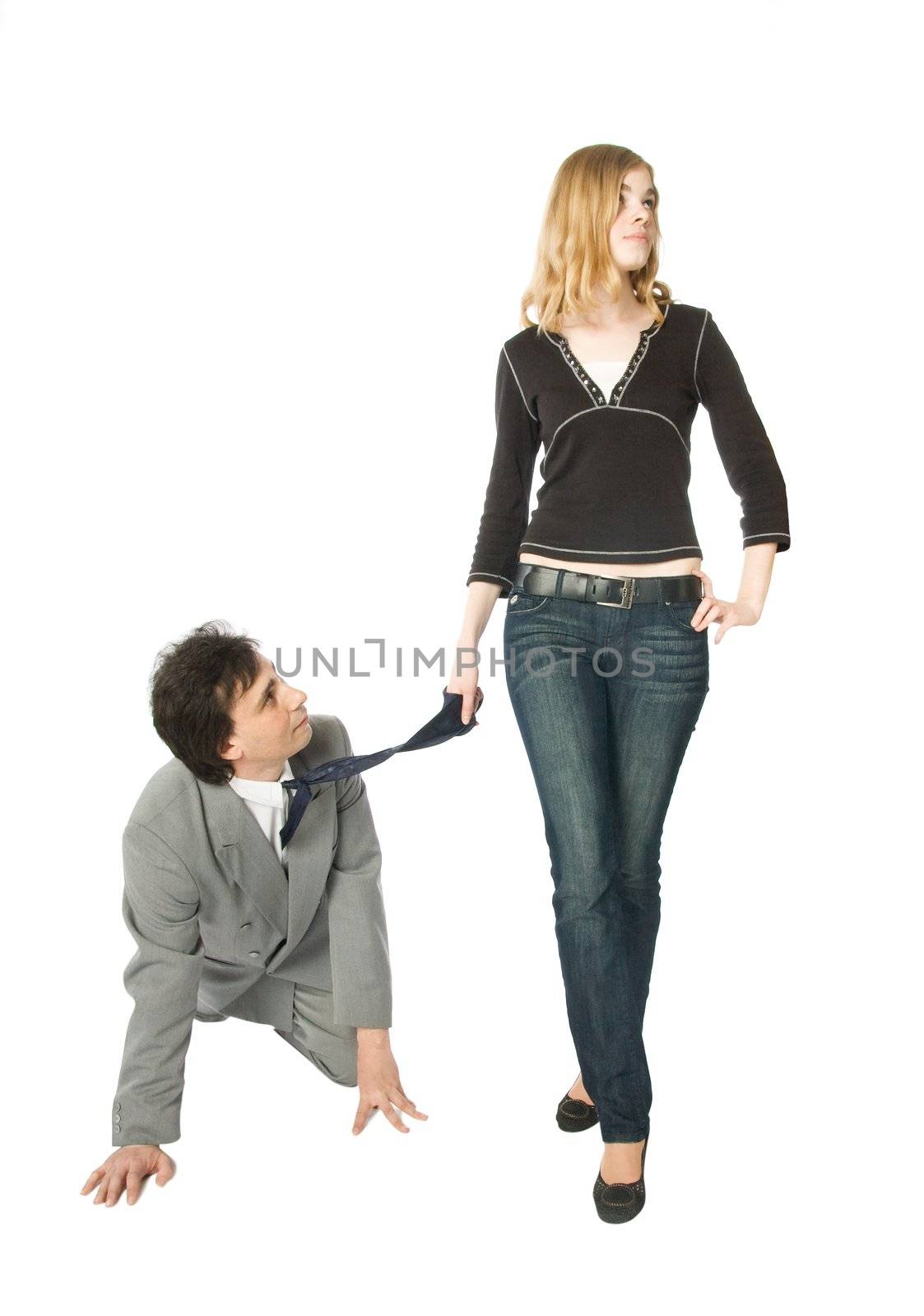 A man on all fours and a young woman pulling him by a necktie