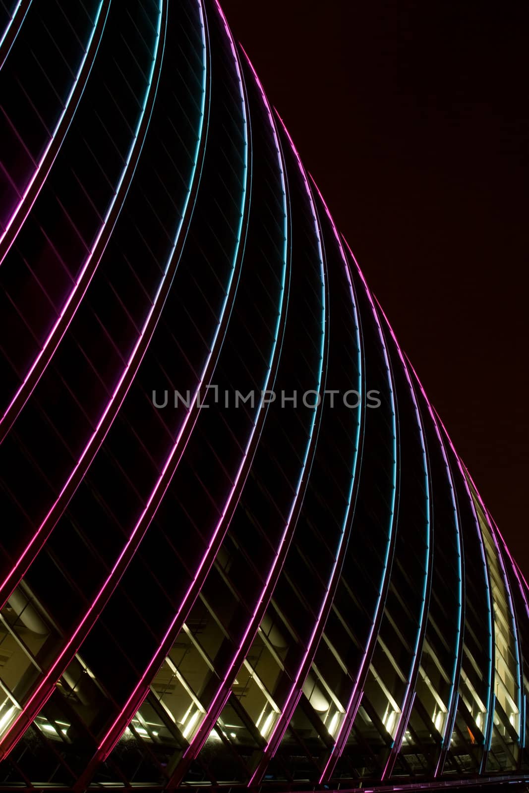 Illuminated skyscraper facade at night in downtown