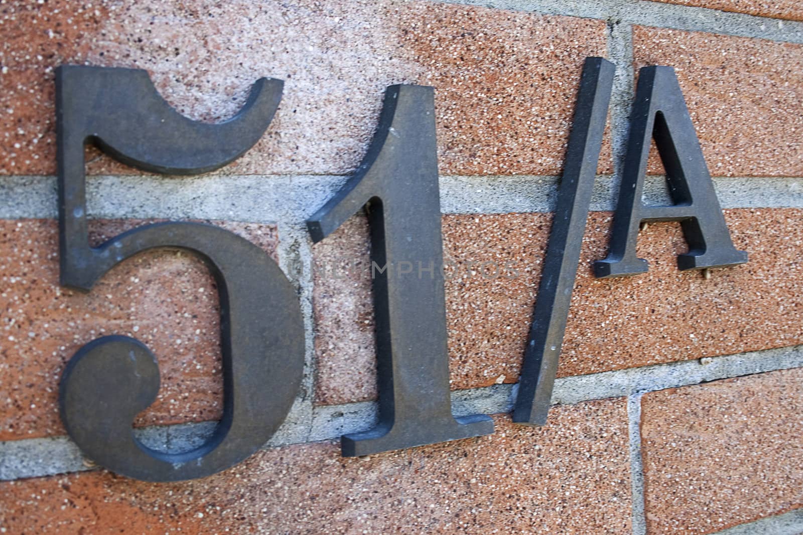 civic number of iron on brick of an private house