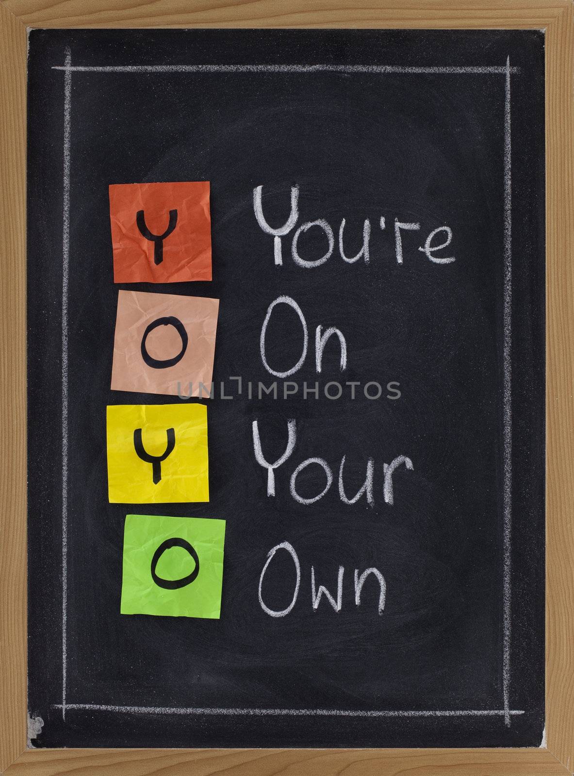 YOYO acronym (you are on your own), sticky notes and white chalk handwriting on blackboard