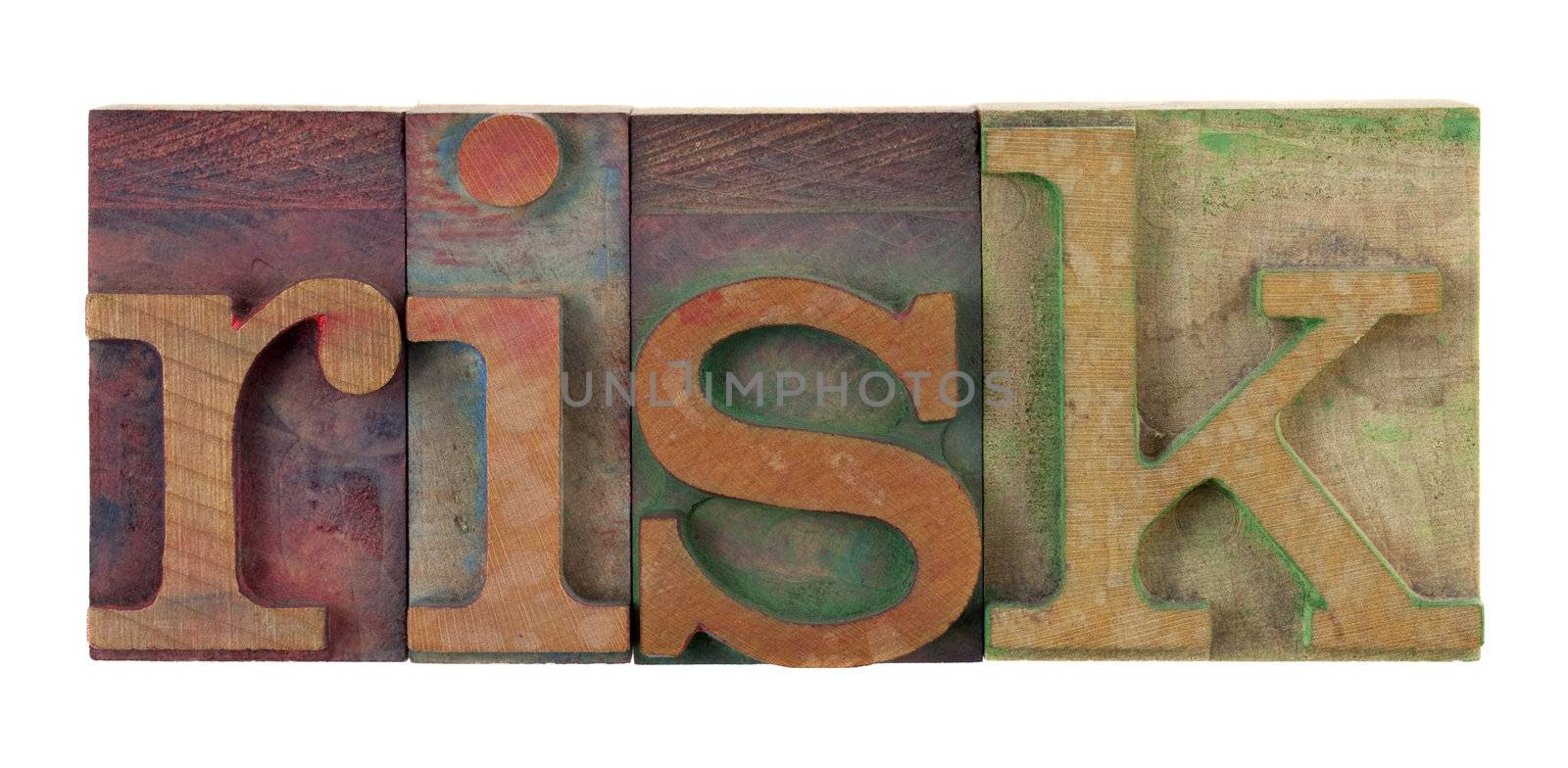 the word risk in vintage wooden letterpress type blocks, stained by color ink, isolated on white