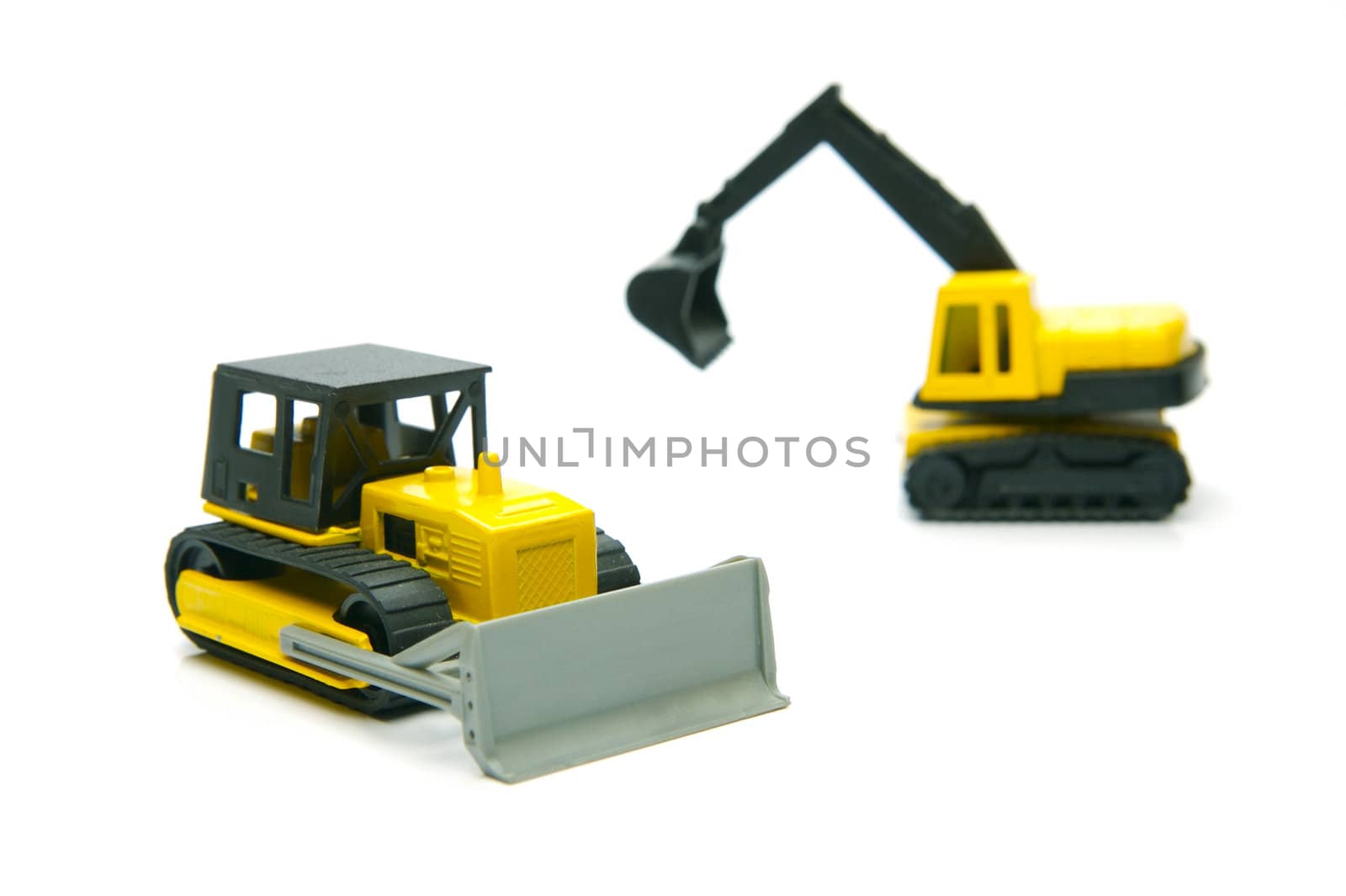 Miniature model earth moving equipment isolated against a white background