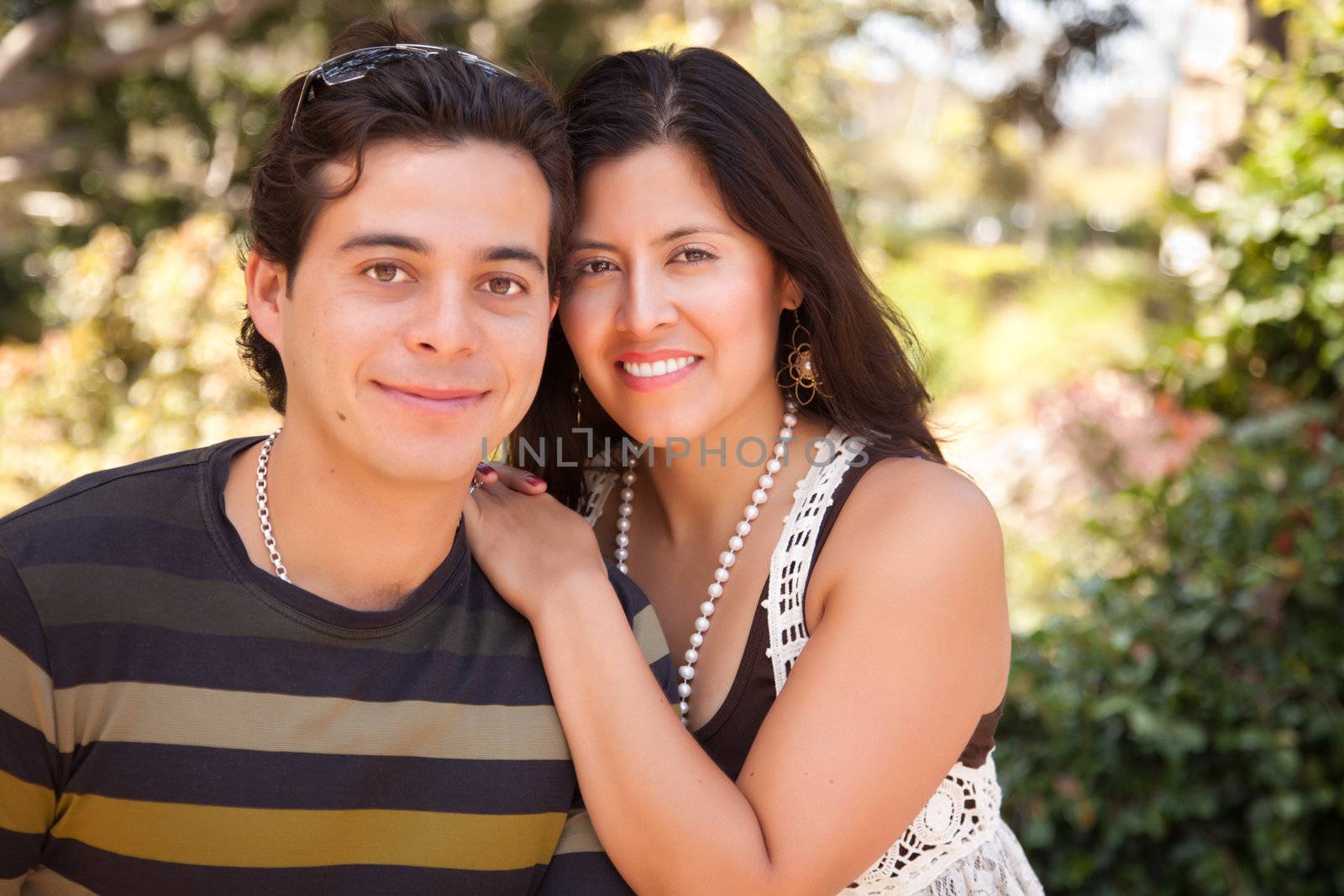 Attractive Hispanic Couple Portrait Enjoying Each Other Outdoors.