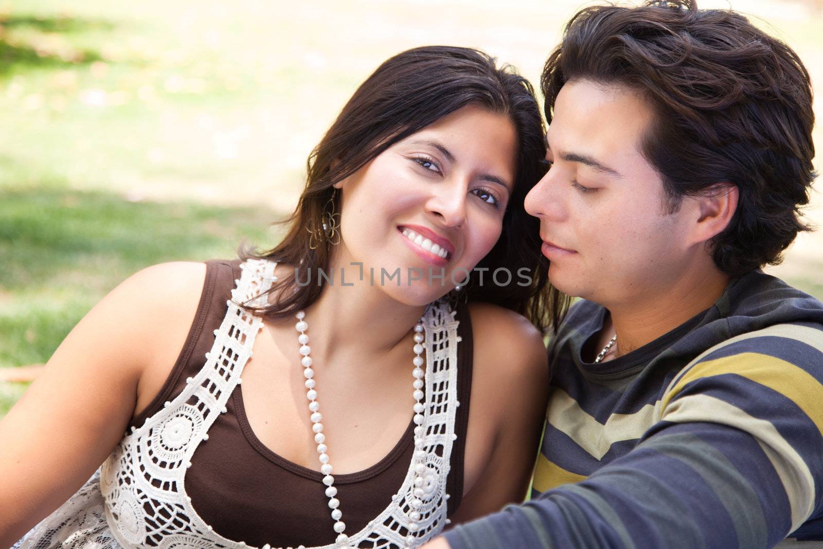 Attractive Hispanic Couple Portrait Enjoying Each Other Outdoors.