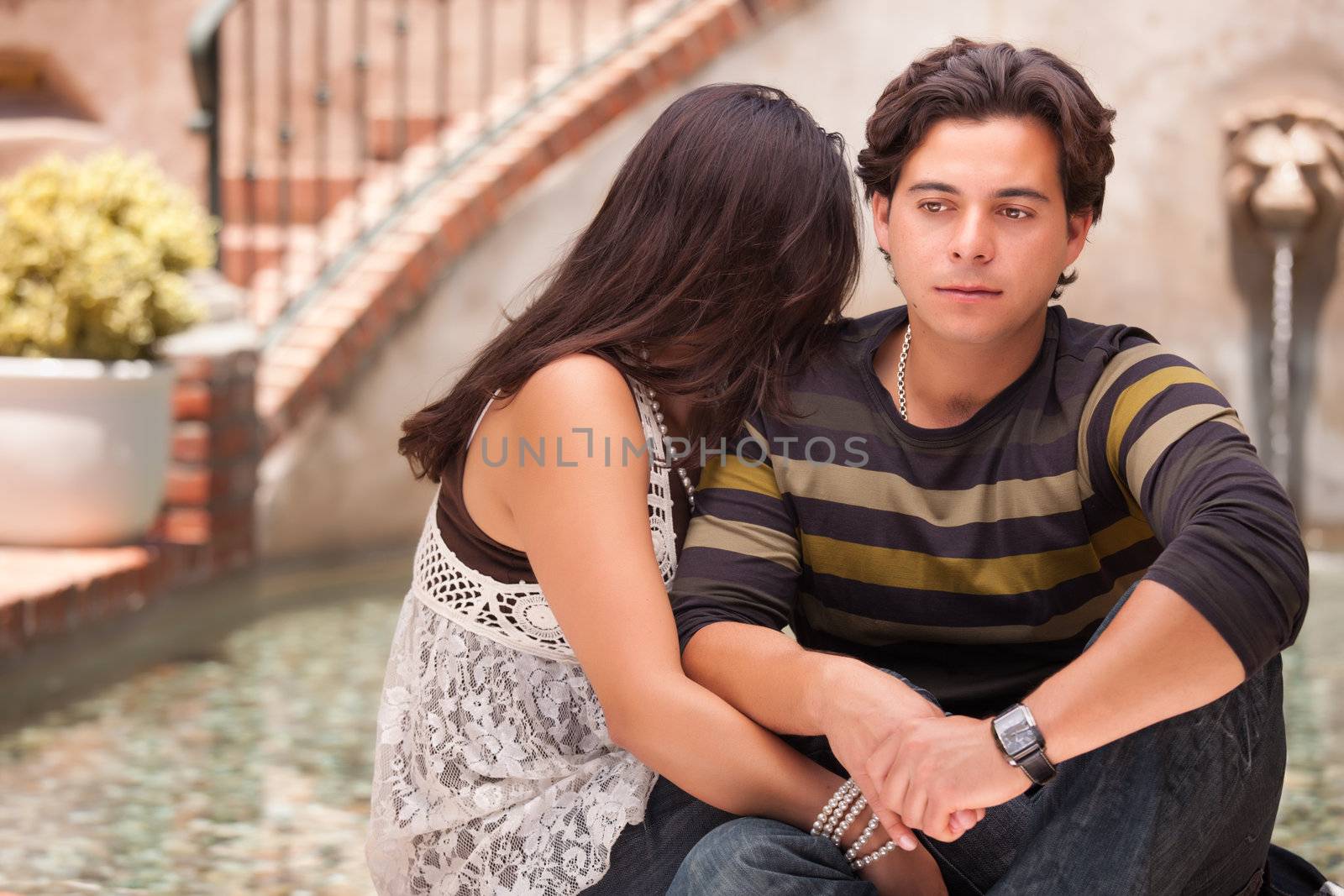 Attractive Hispanic Couple During A Serious Moment at a Fountain.