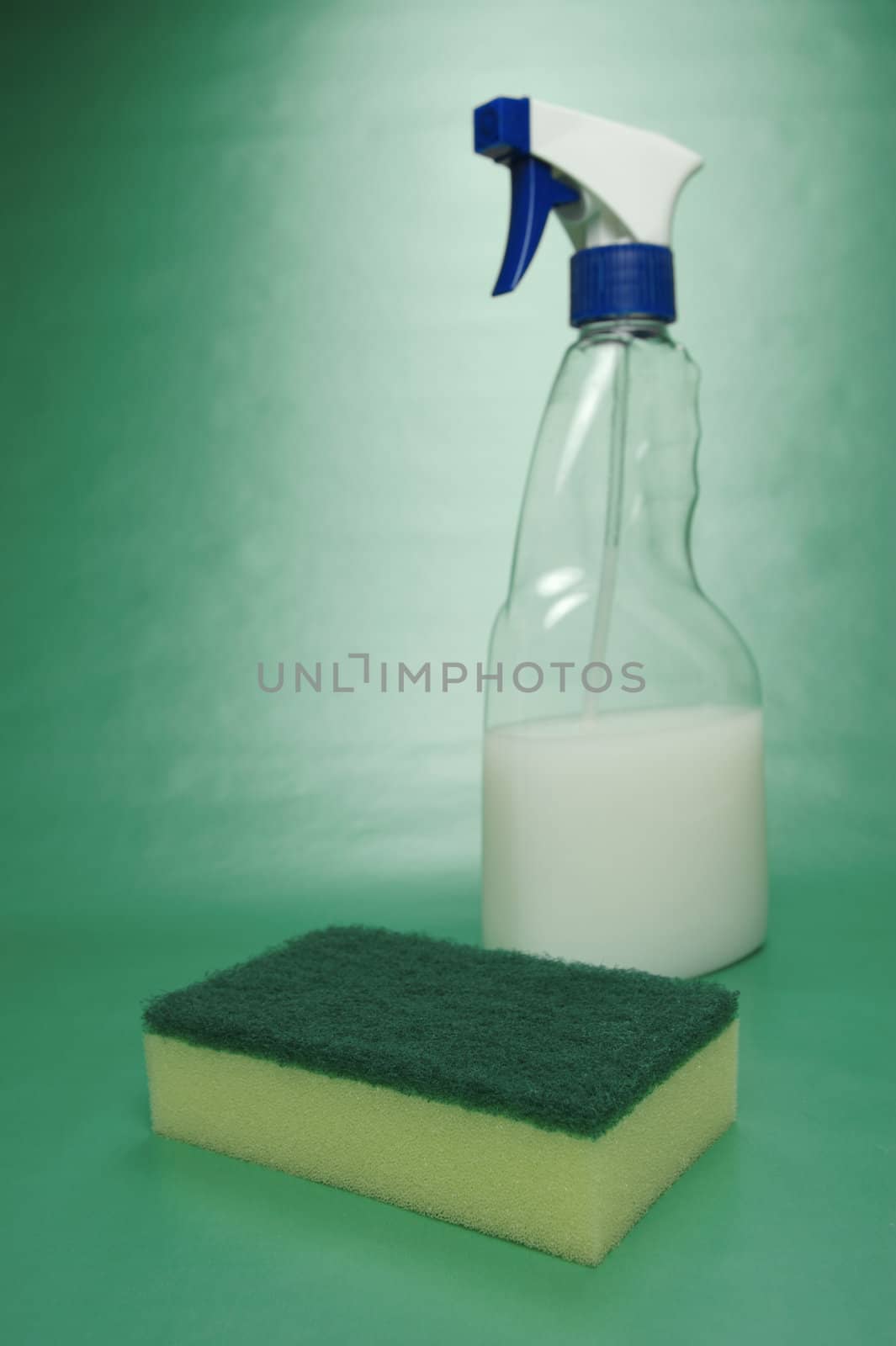 Cleaning products isolated against a green background