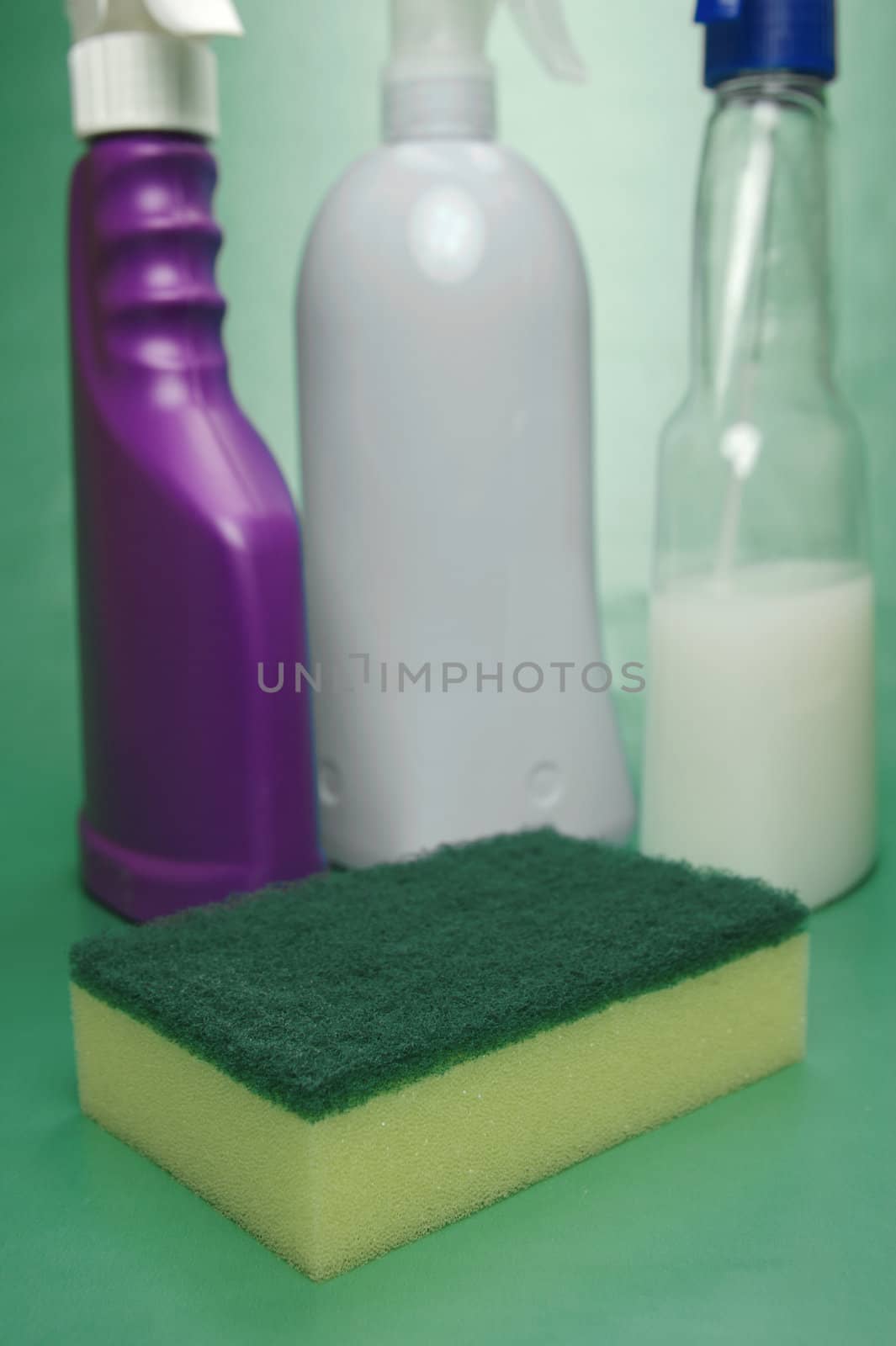 Cleaning products isolated against a green background