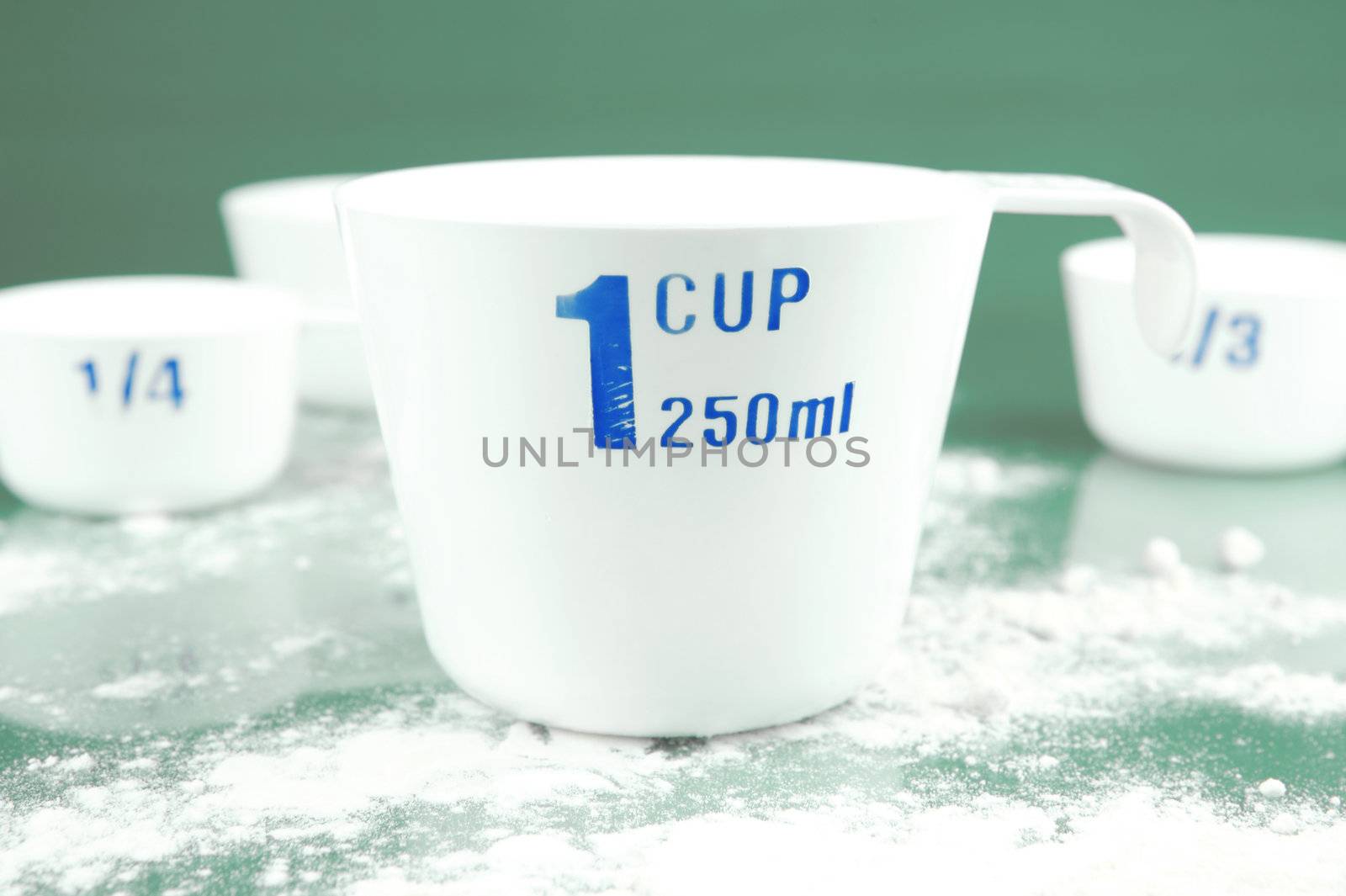 Measuring cups isolated against a green background