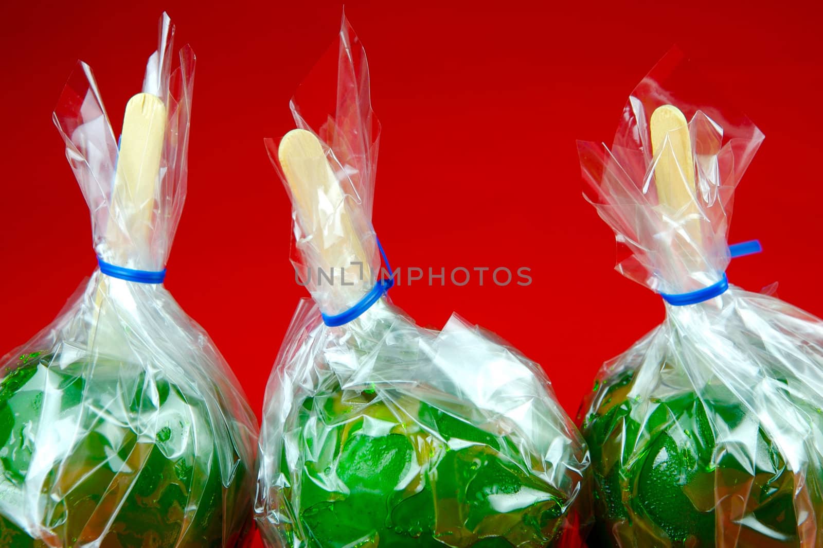 Green toffee apples isolated against a red background