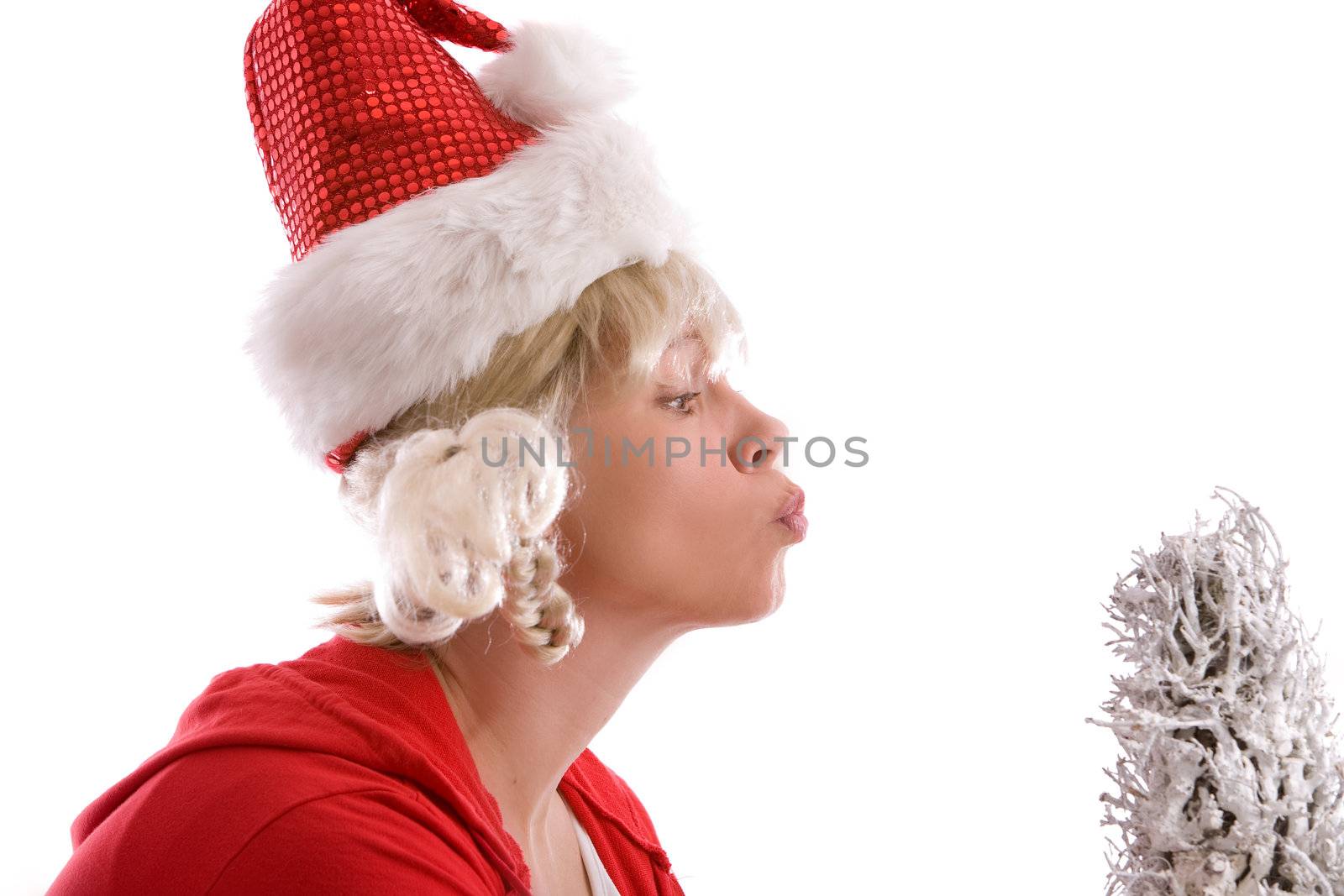 Woman with christmas hat kissing the christmas tree