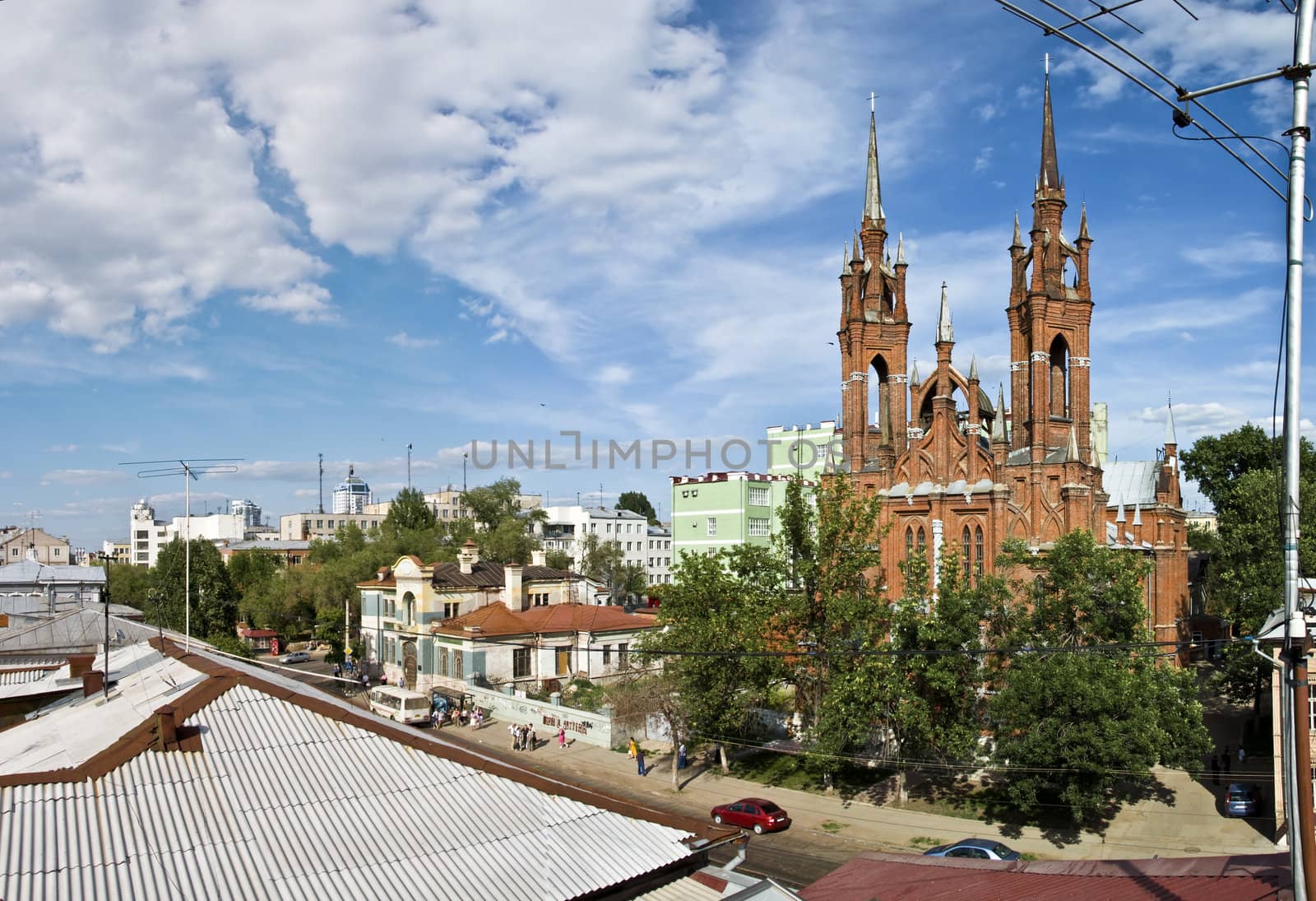 Panorama of large size. Urban Catholic cathedral in the heart of the city of Samara. Russia. Against the background of blue sky with clouds. Taken from the roof of a house.
