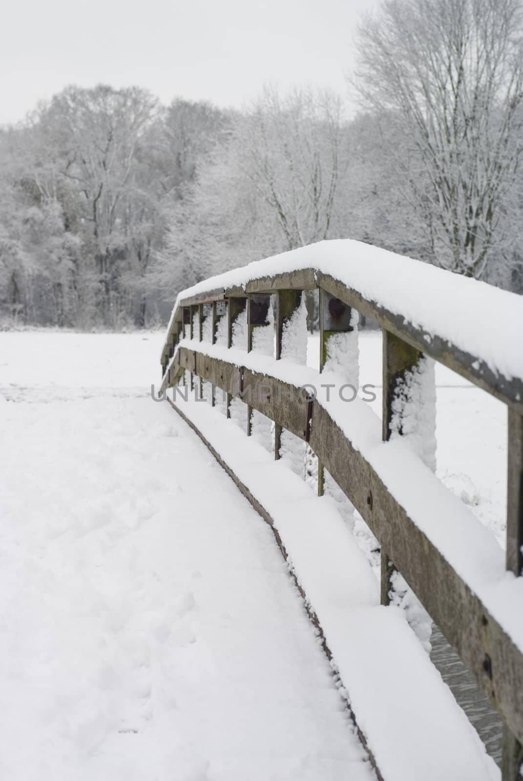 Part of a wooden bridge covered with snow.