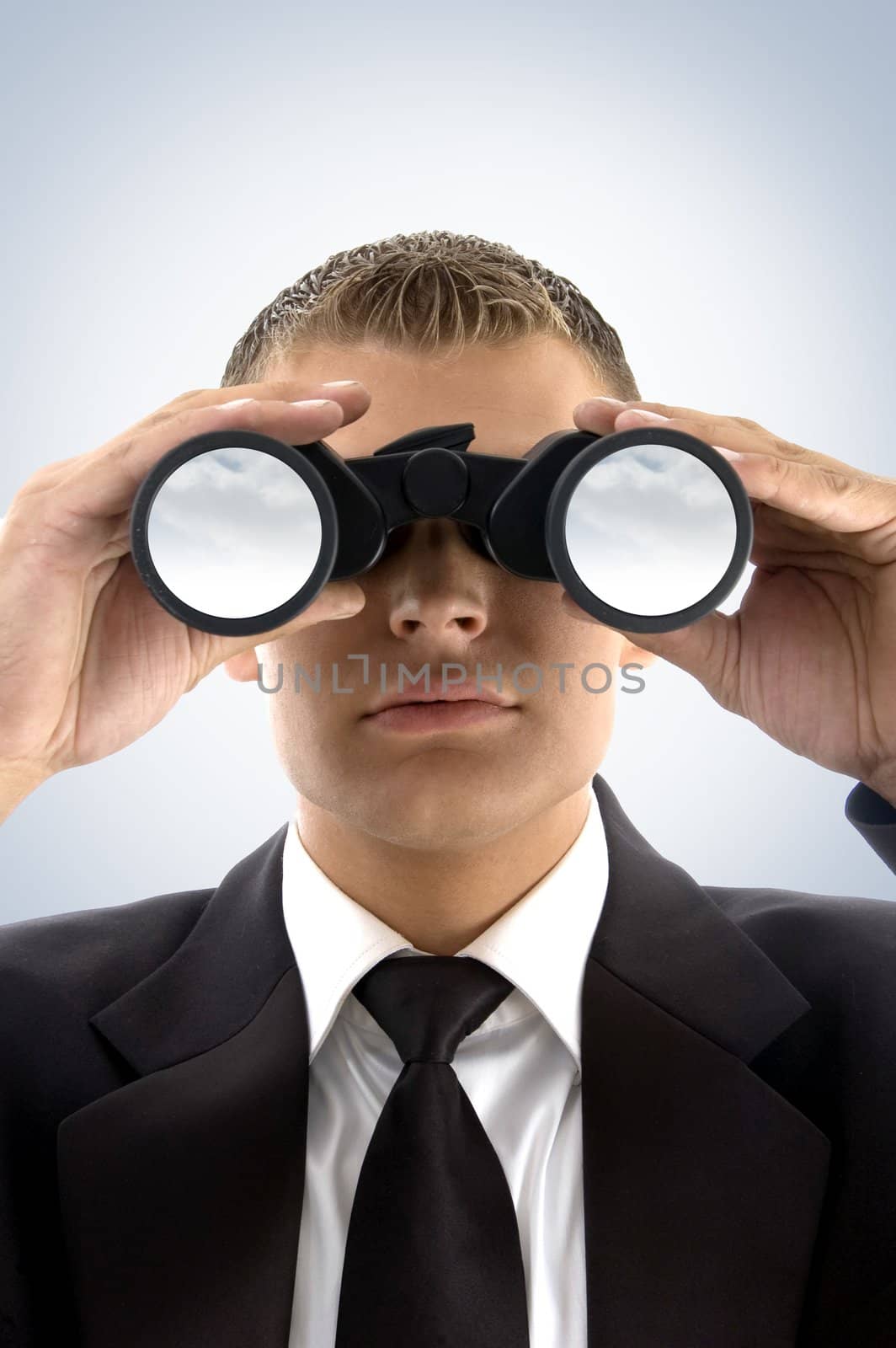 young businessman using binoculars looking at the sky