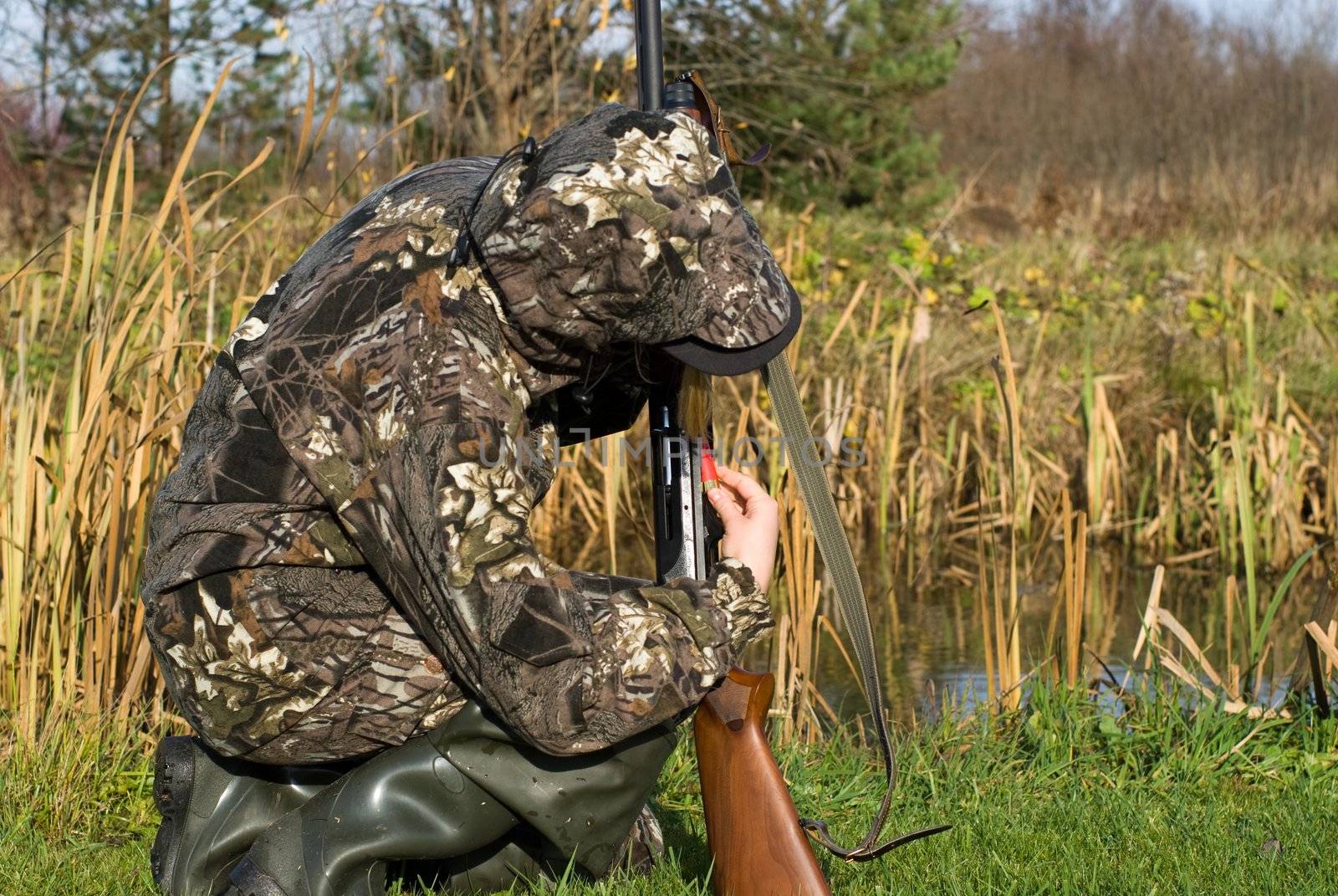 The girl dressed in a camouflage charges a shot-gun