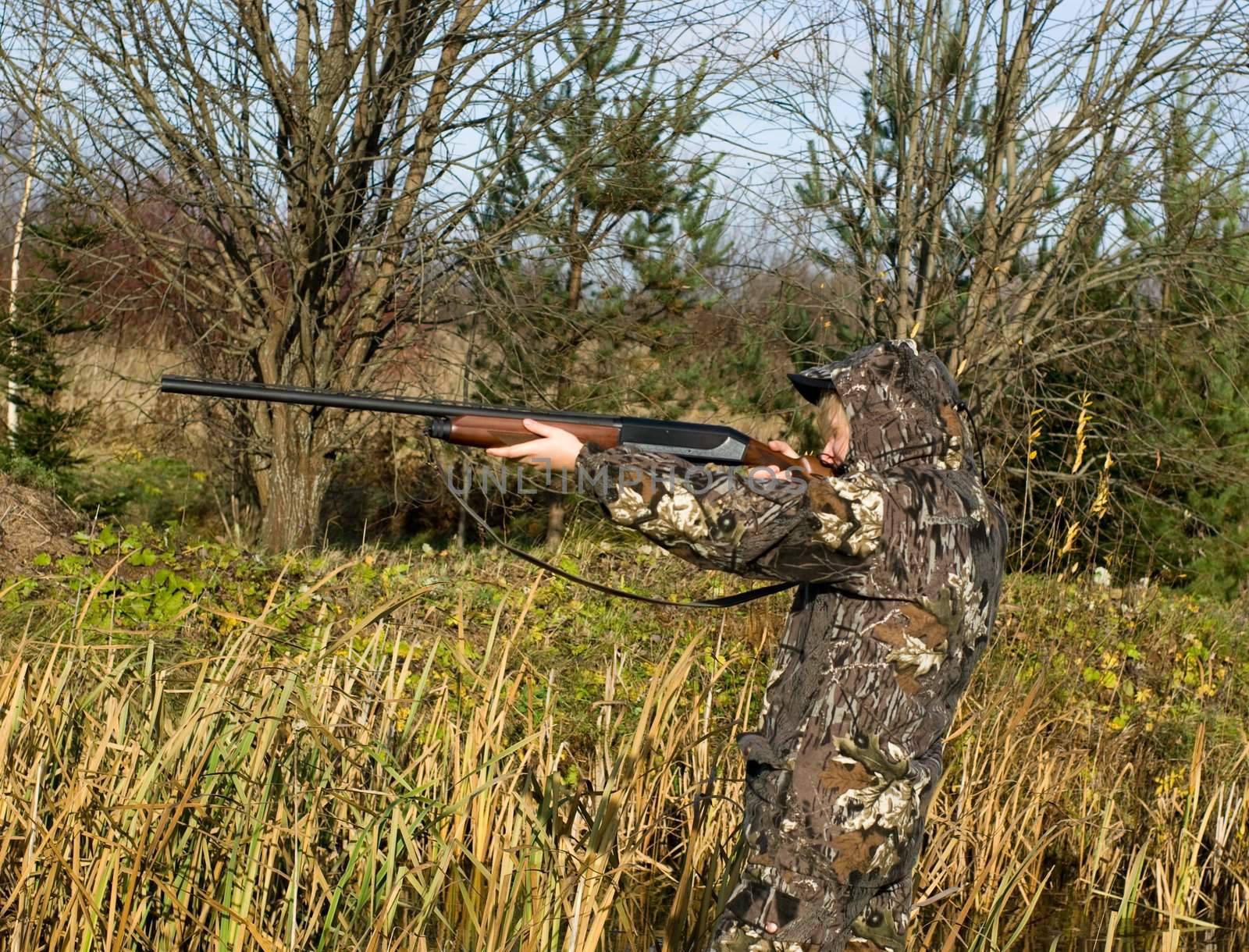 The girl in a camouflage aiming from a gun