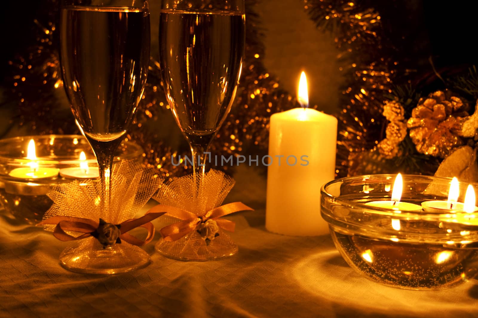 two glasses of champagne lightening with candle with decoration