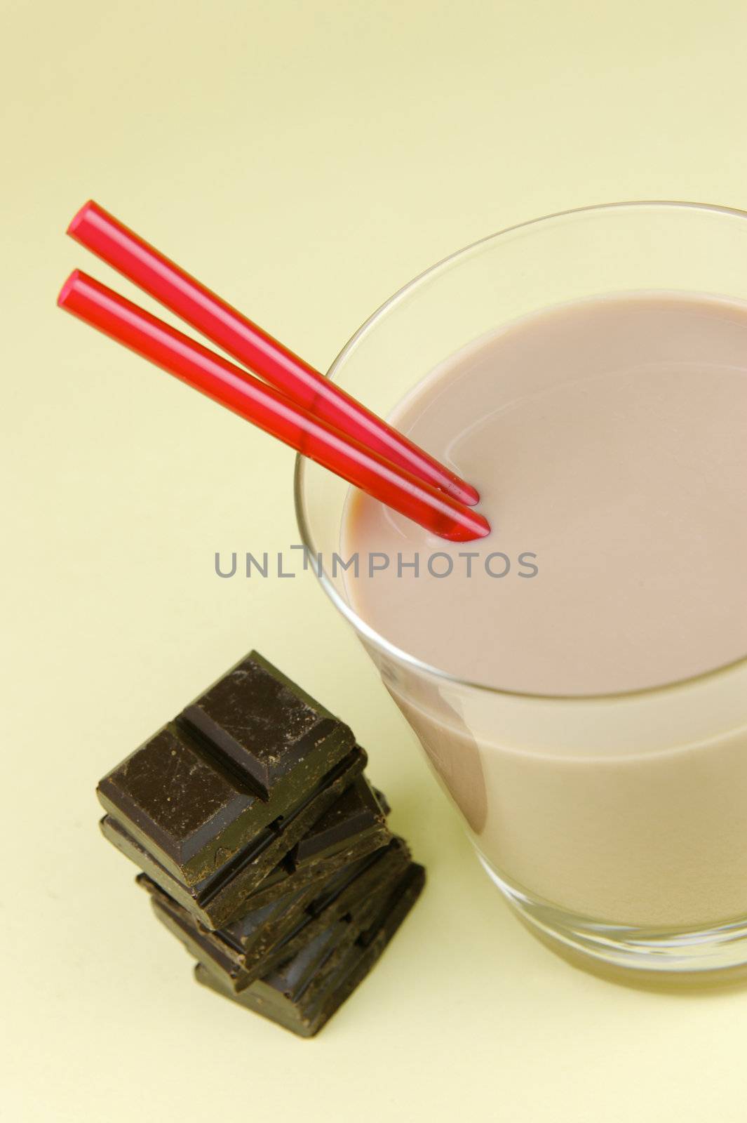 A glass of chocolate milk isolated against a yellow background