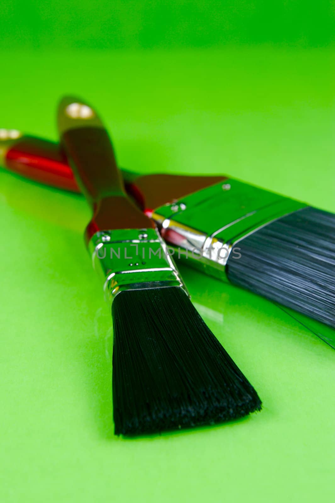 Paint brushes isolated against a green background