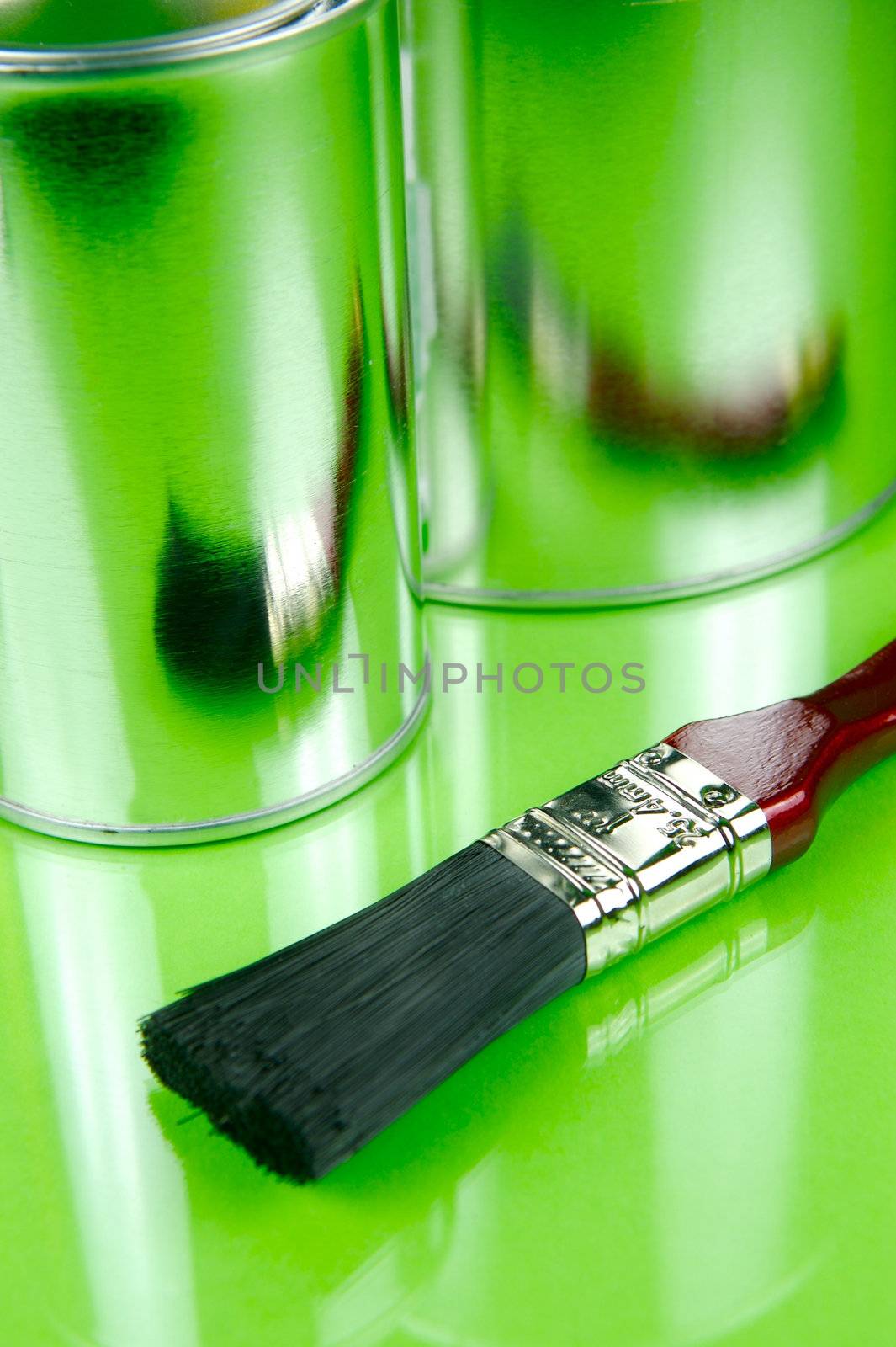 Paints and brushes isolated against a green background